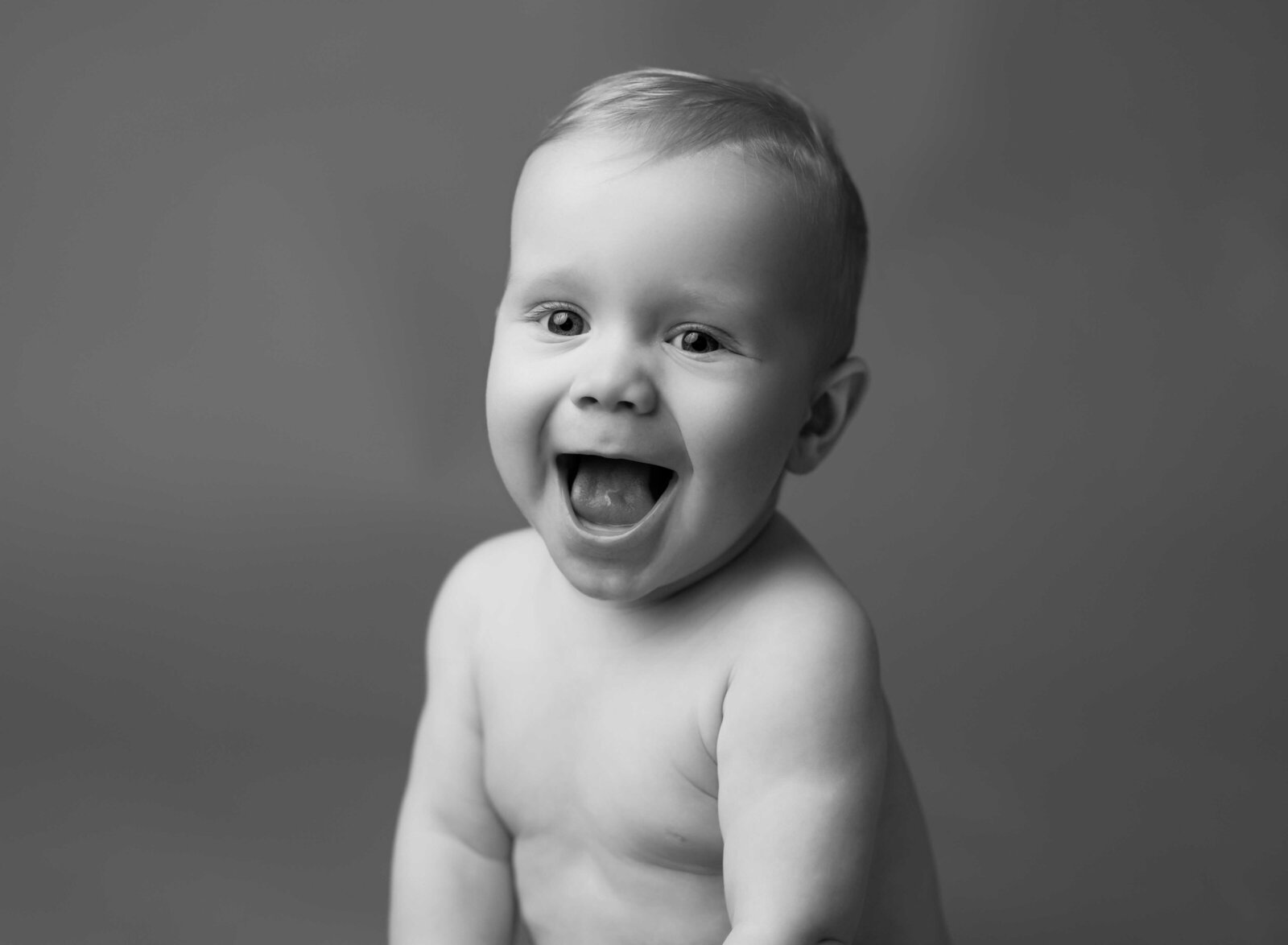 B&W photo of baby smiling really big. Baby milestone photo taken by Jenni Nikki Photography in Atlanta, GA. 