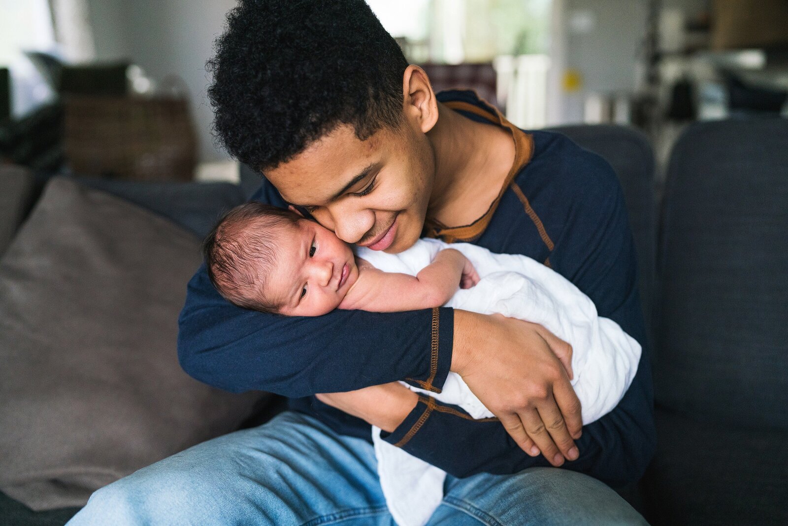 Big brother smiling holding newborn baby brother