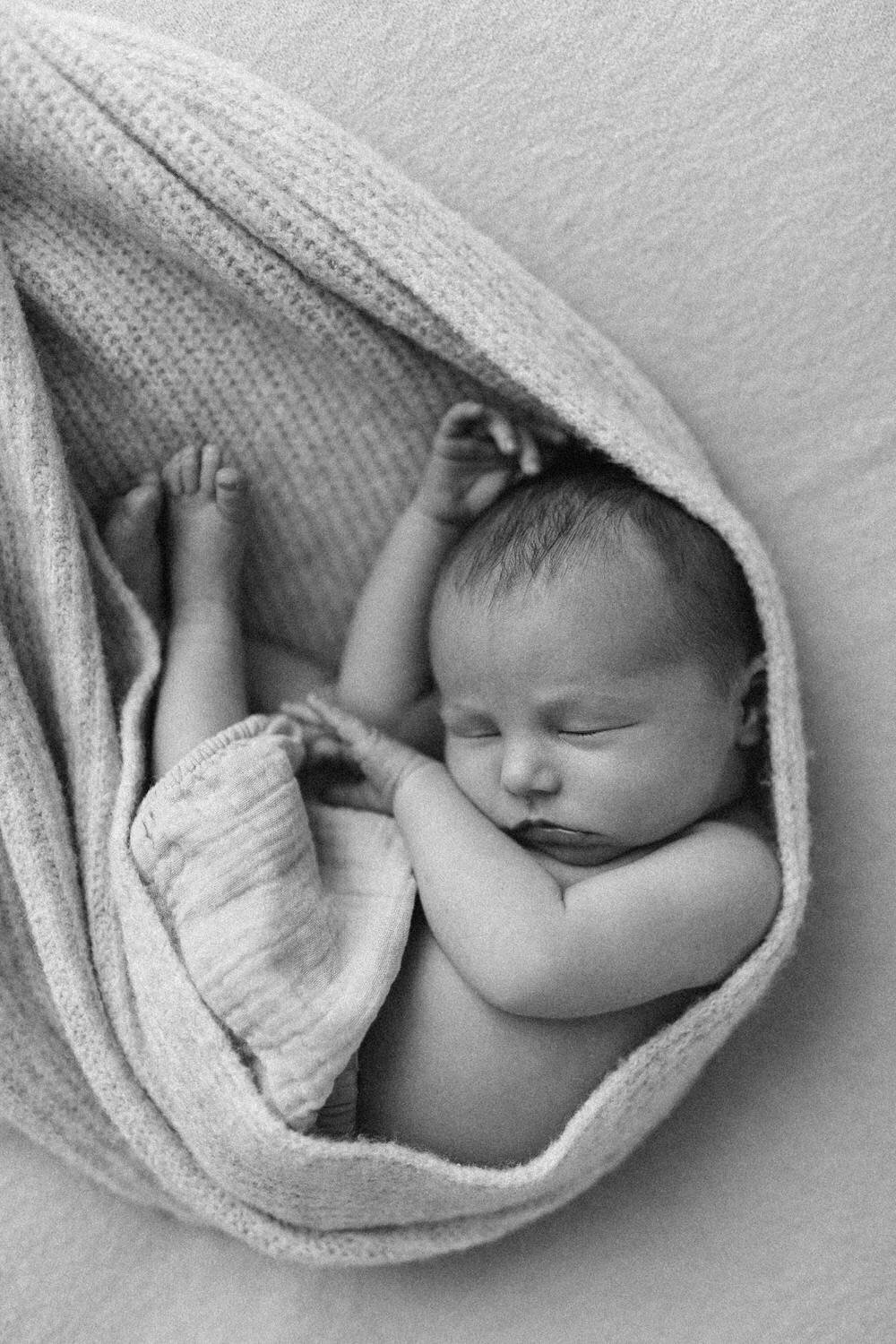 Asleep newborn baby wrapped in blanket asleep