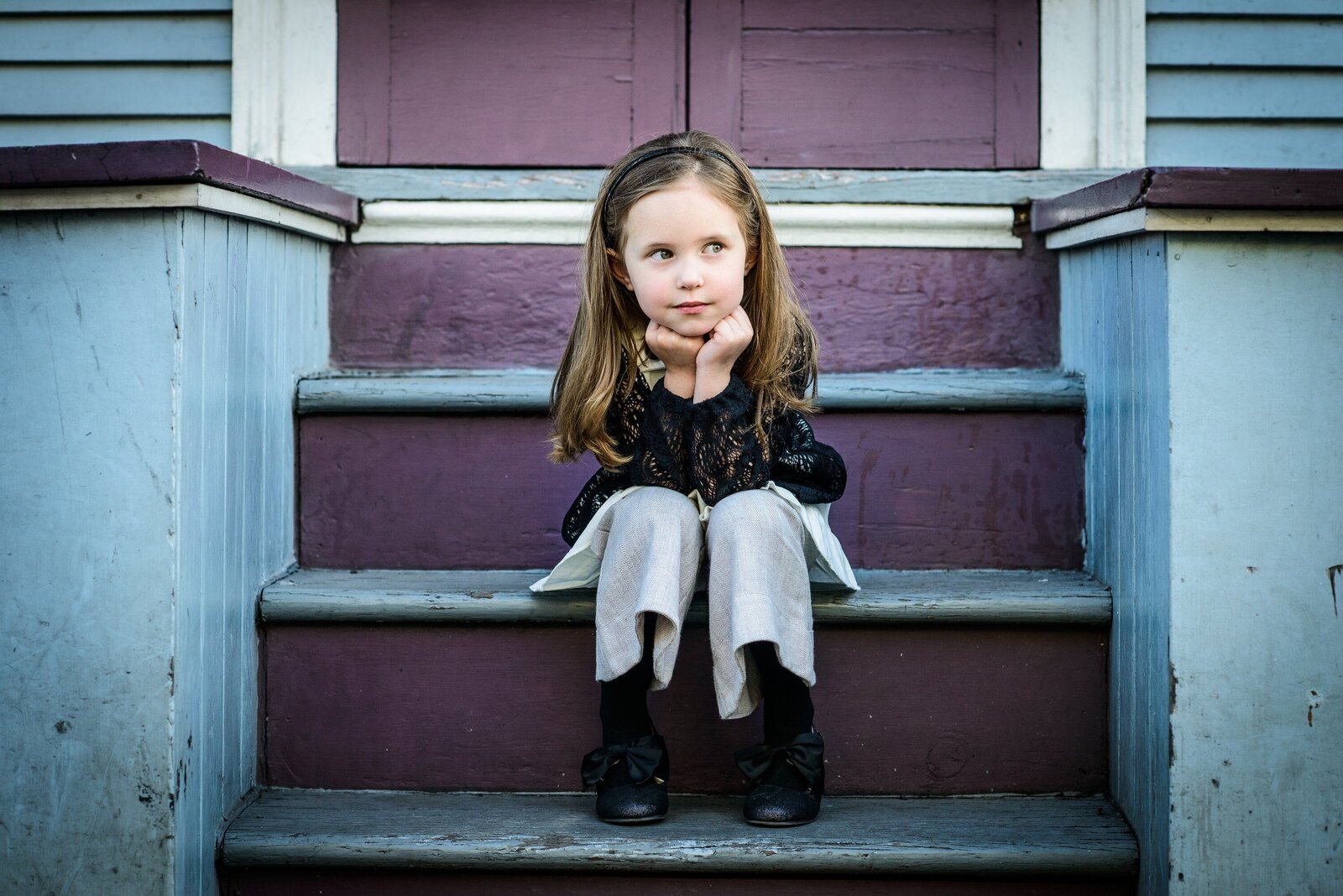 Little girl sitting on purple steps in the French Quarter
