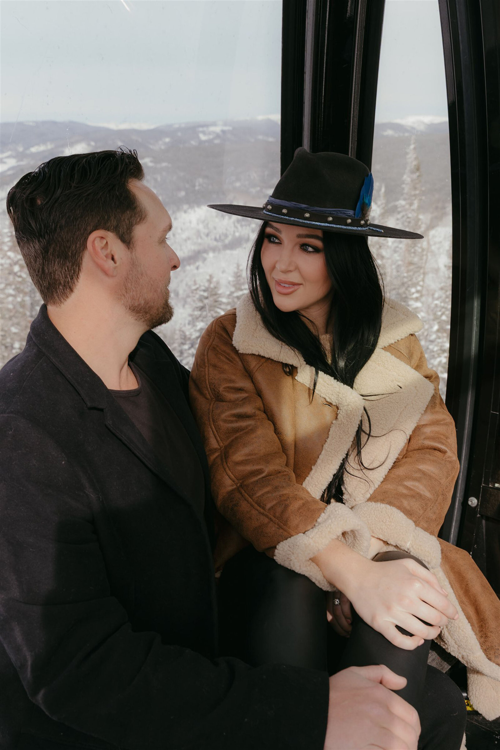 Couple riding gondola during Aspen winter engagement session