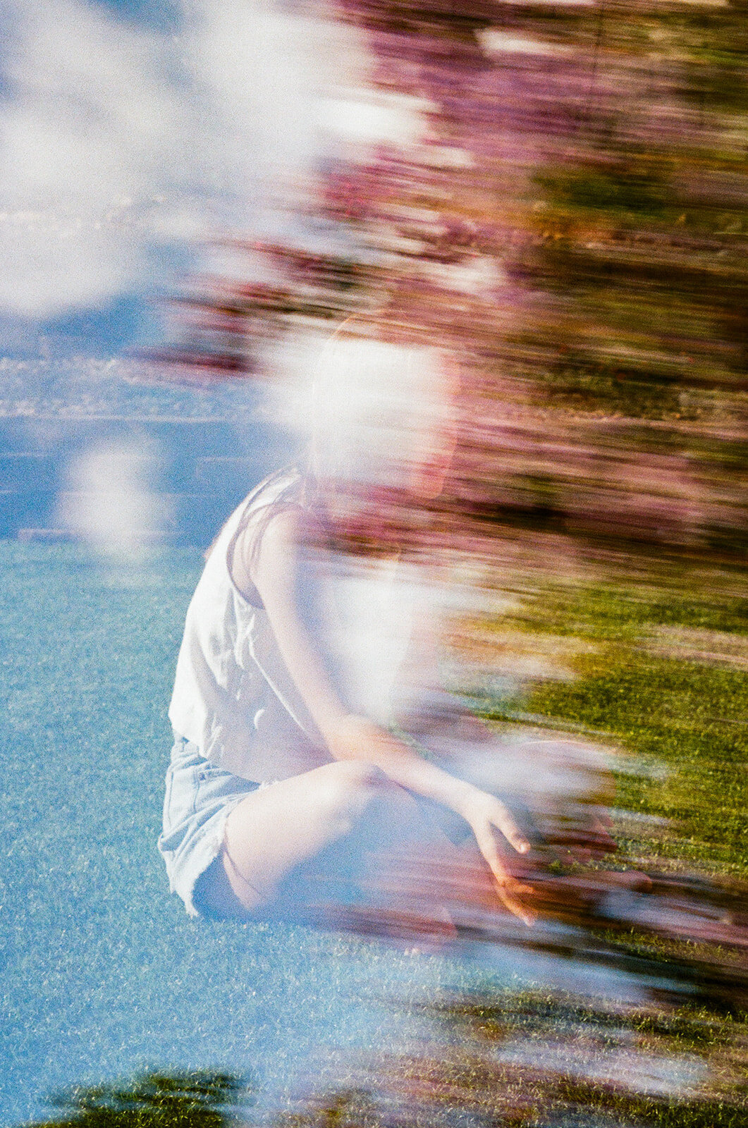 double exposure on film of girl sitting on grass with florals