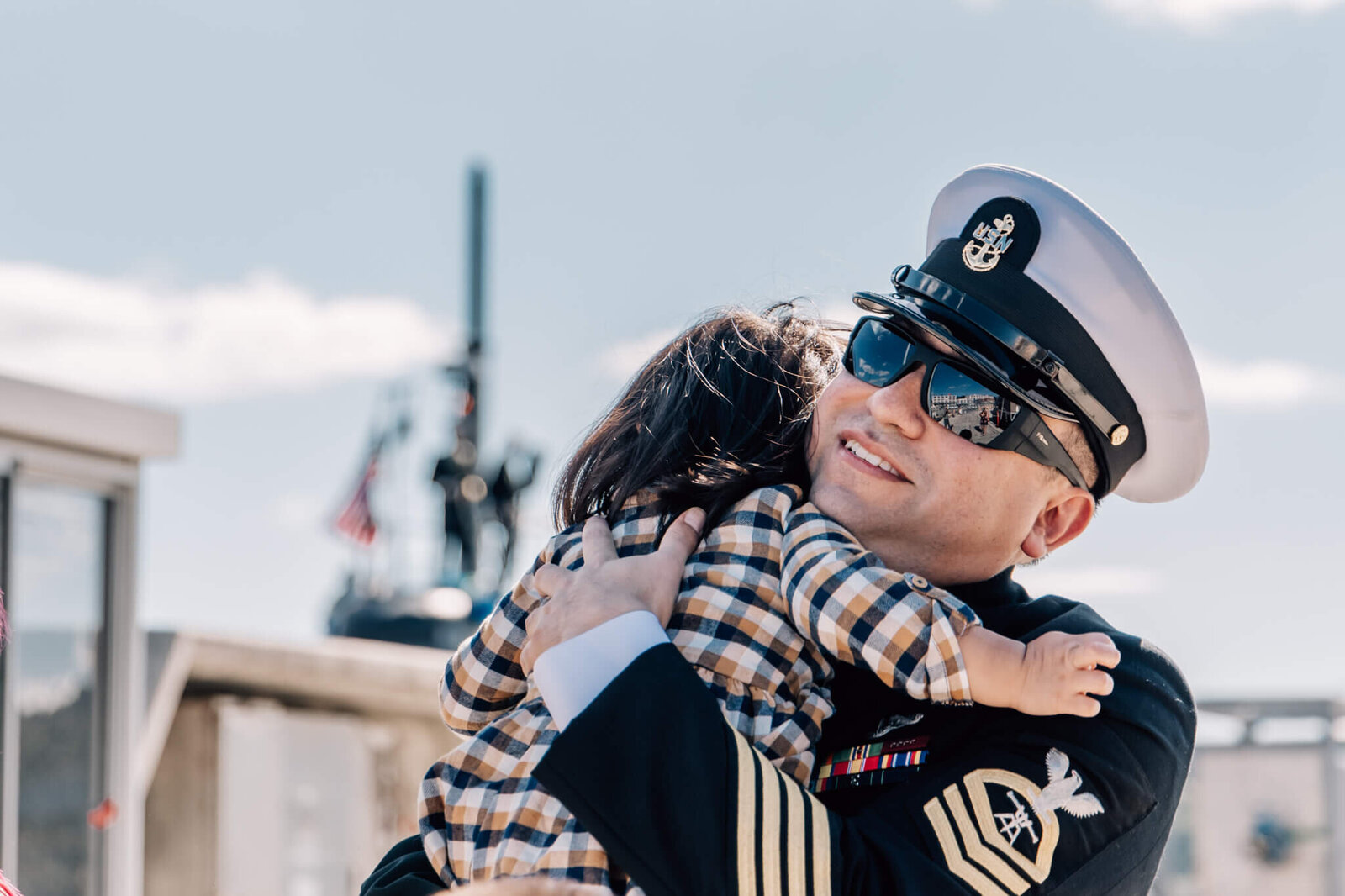 Chief Petty Officer hugging child in emotional homecoming reunion for USS Montpelier in Groton, CT.