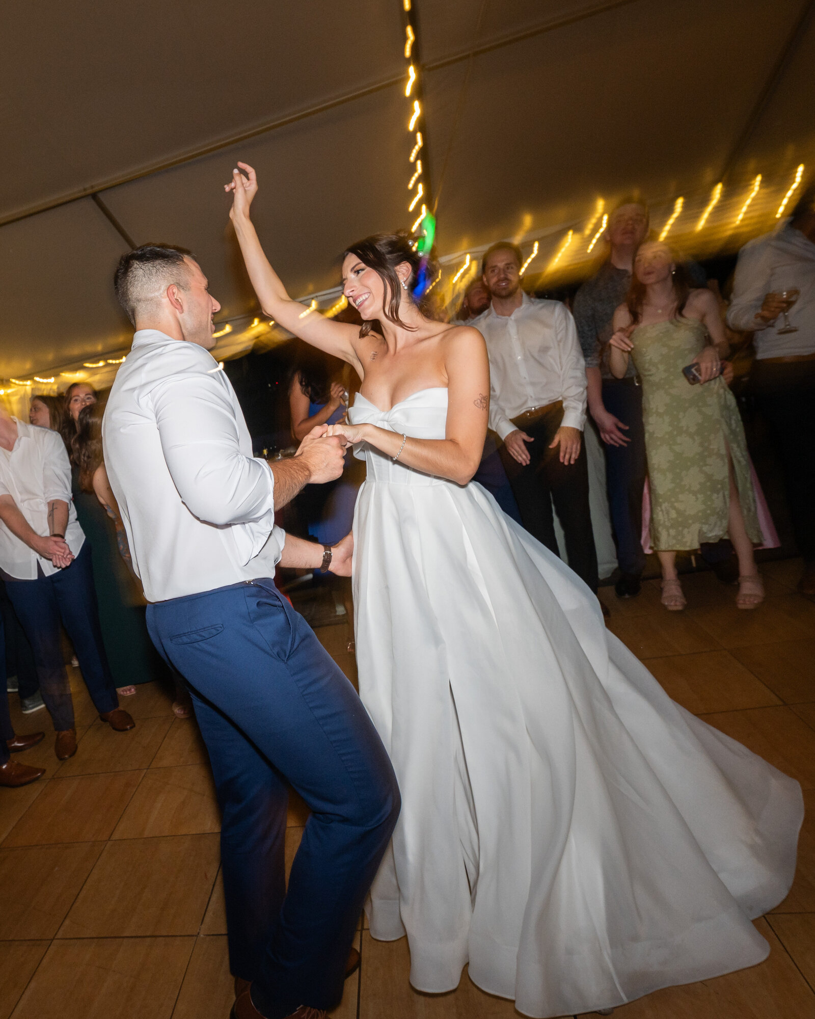 Action shot of a bride and groom dancing at their wedding reception. Slightly blurry to show movement.
