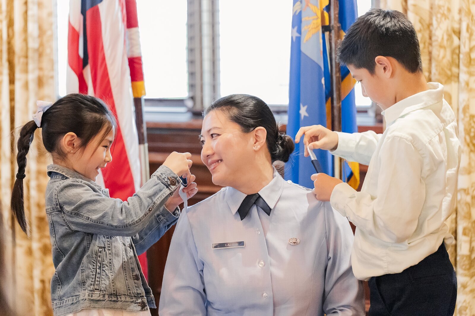 Children pinning their mom's new shoulder boards on during her promotion ceremony