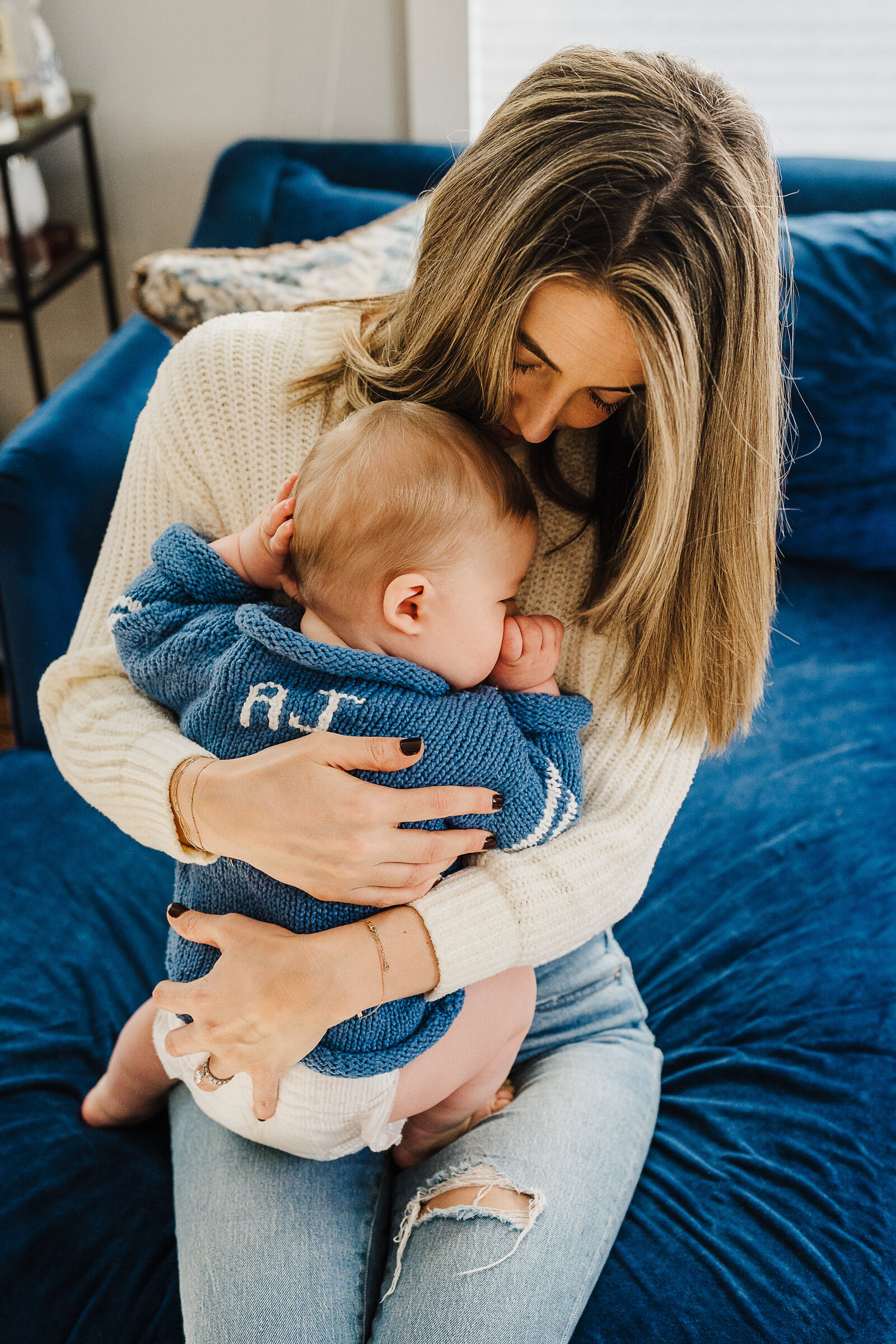 baby boy snuggles against mom in living room