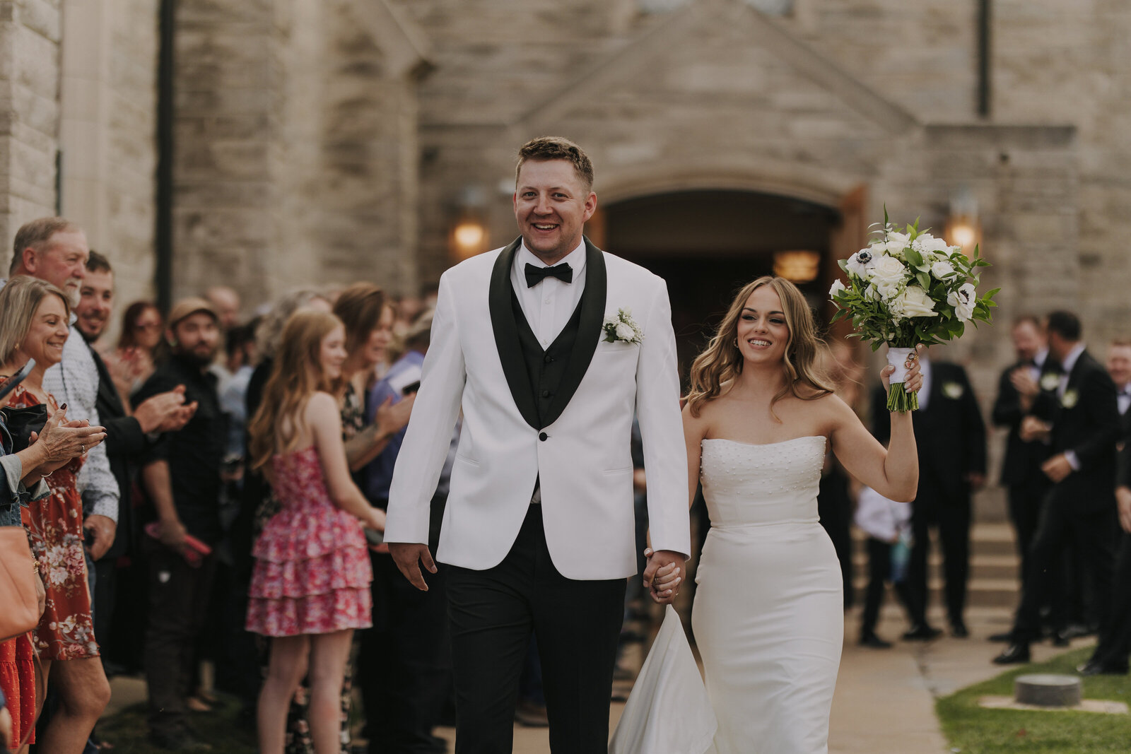 Newlyweds leaving their hometown church after their classic fall wedding in Beatrice, Nebraska. Photo by Maryse Photography