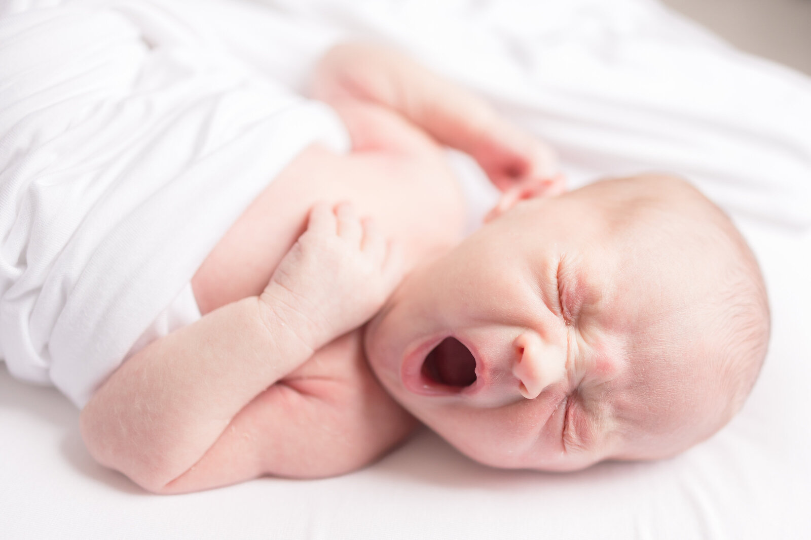 newborn baby yawning in swaddle