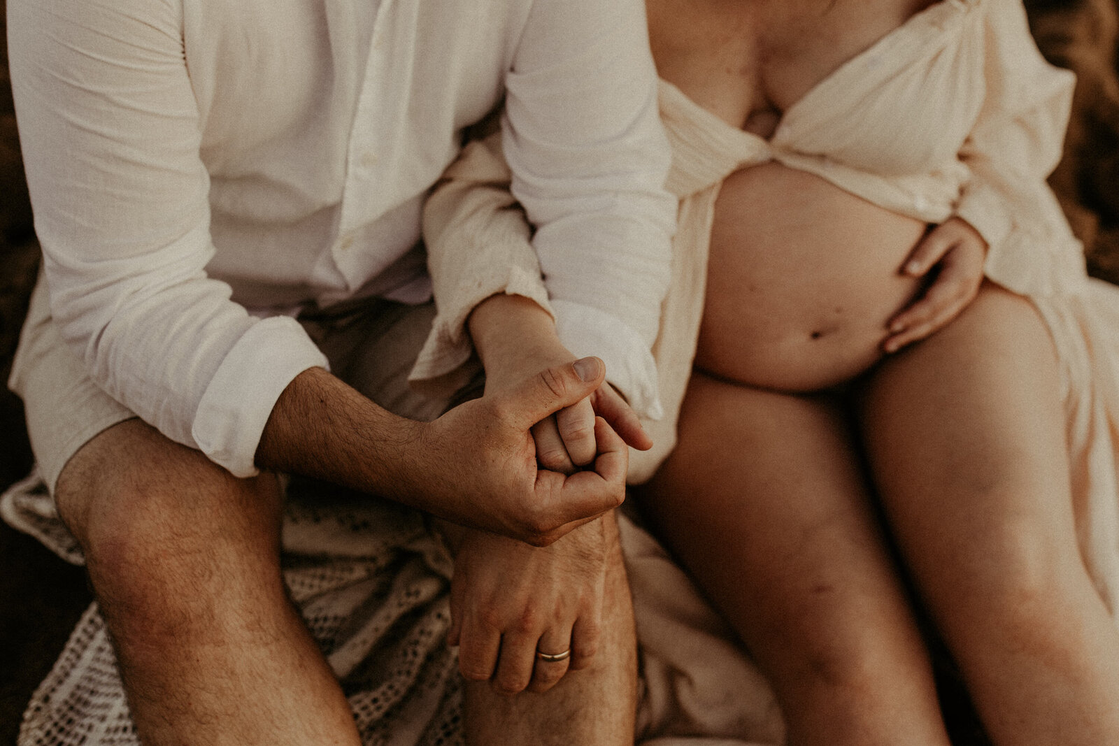 gravidfotografering med sin partner som håller hand med mamman