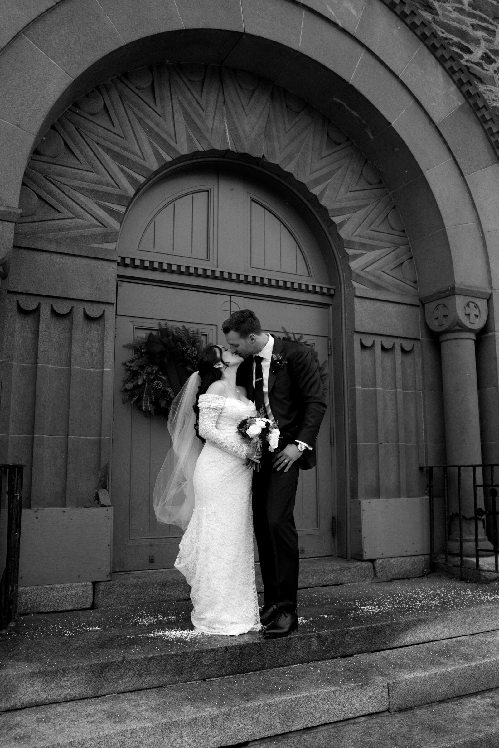 bride and groom kissing in front of church in woodstock vermont