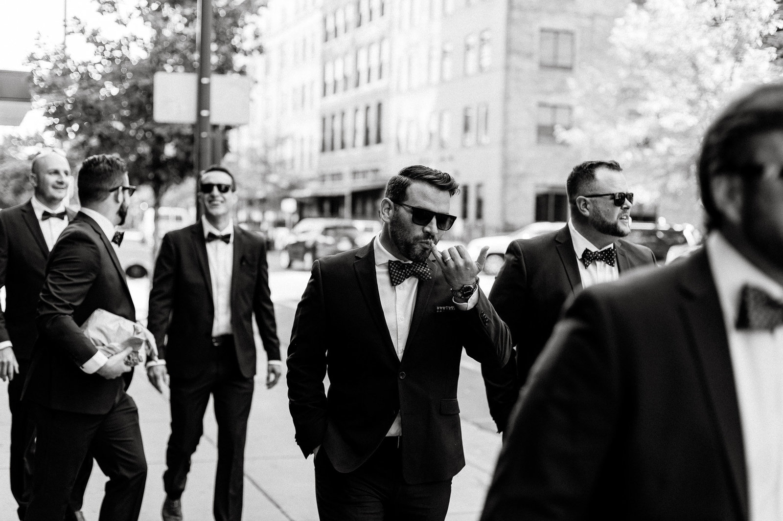 Cool black and white of groomsmen walking to the wedding location together in Denver.