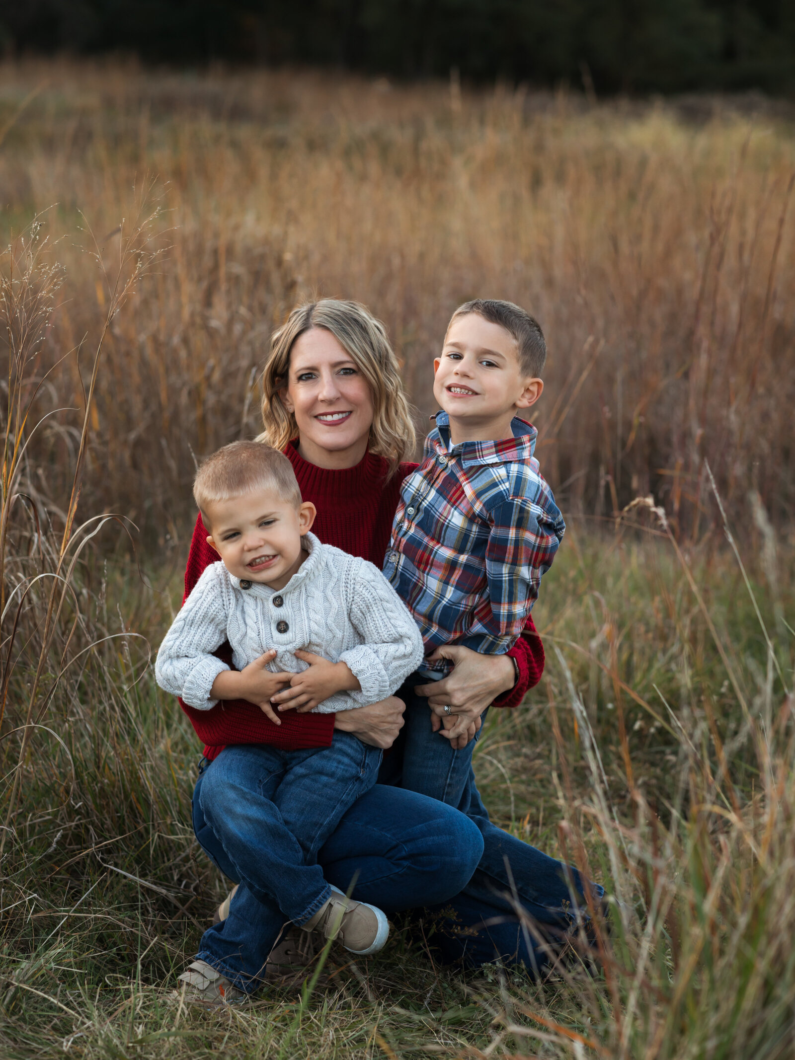 mom holding two sons for family photos