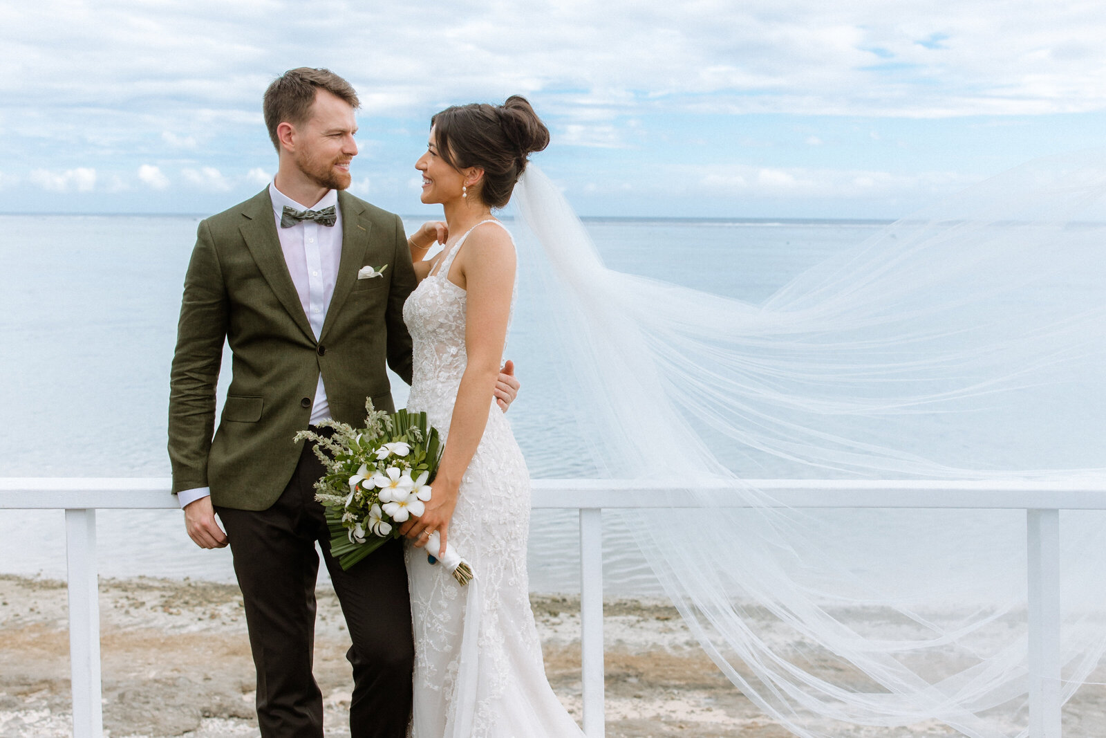 Bride and groom with bride's veil blowing