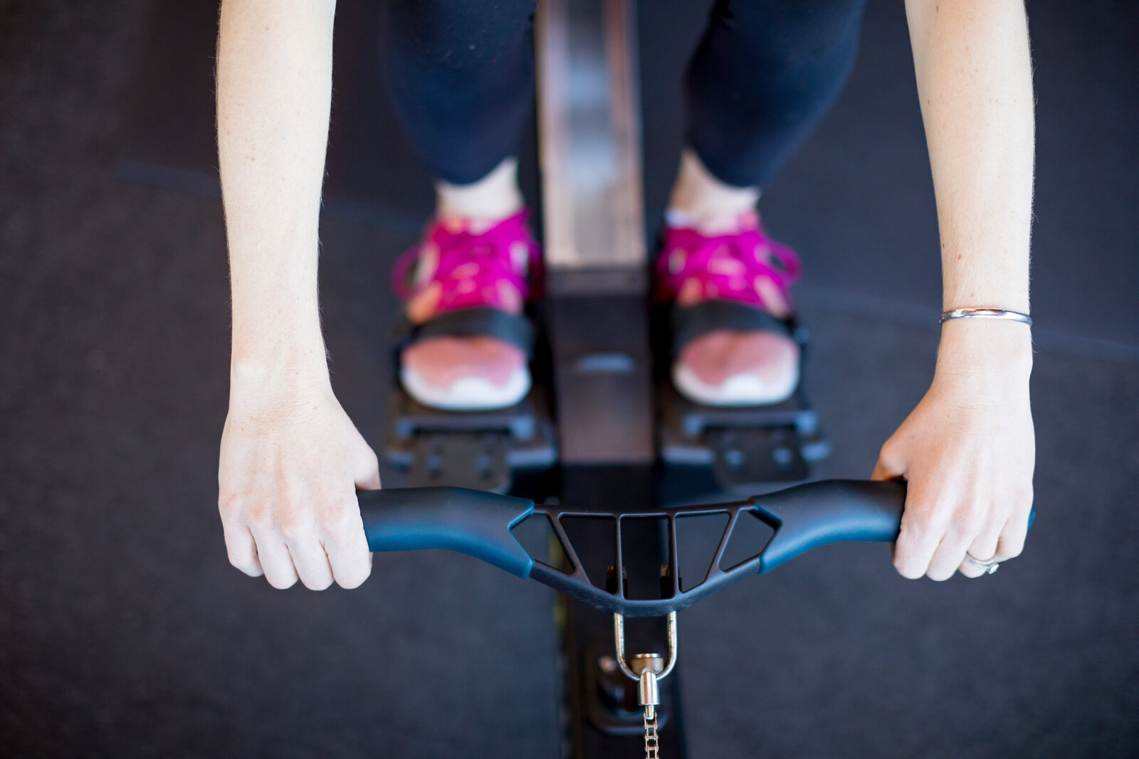 A top down photo of Kristin Hedstrom holding the handle of the Concept2 rowing machine. 