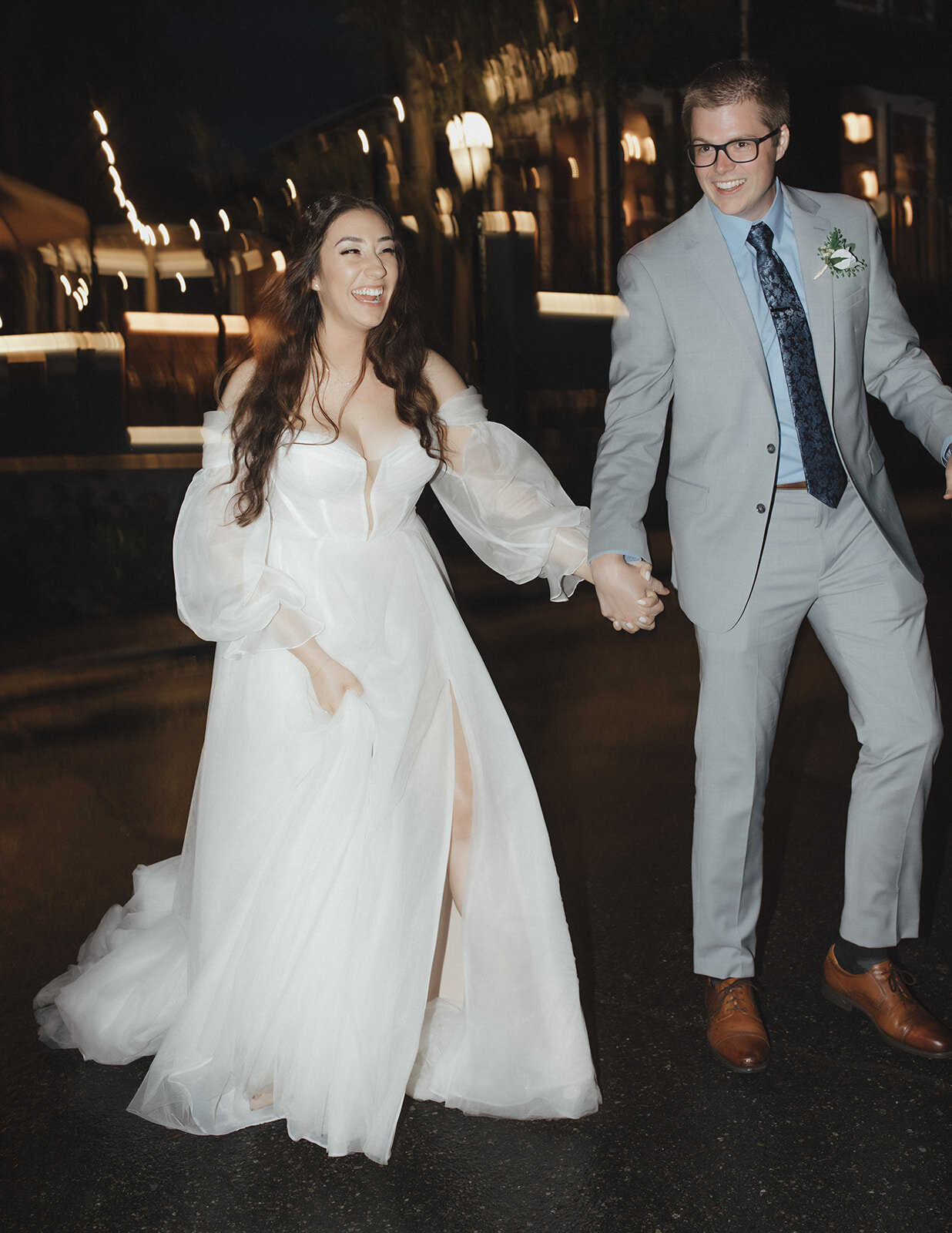 Bride and groom holding each other's hand while happily walking