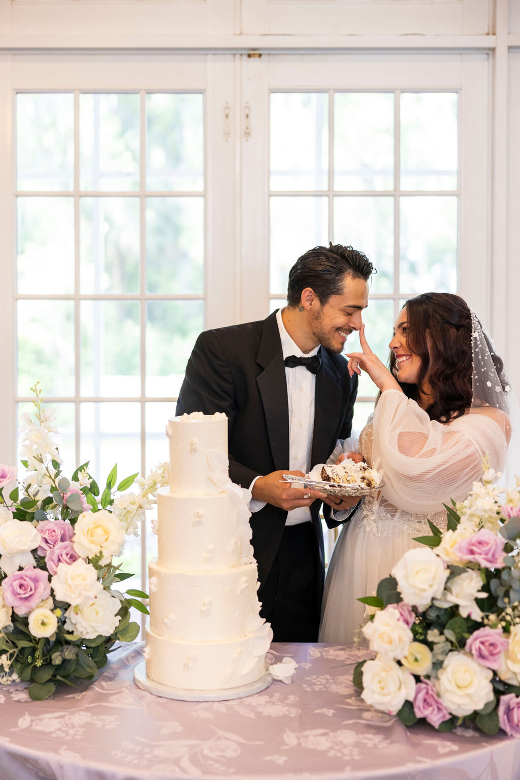 A memorable cake cutting ceremony at Luxmore Grande Estate in Central Florida, featuring stunning silk floral arrangements and a beautifully designed wedding cake. Ideal for a timeless and elegant celebration