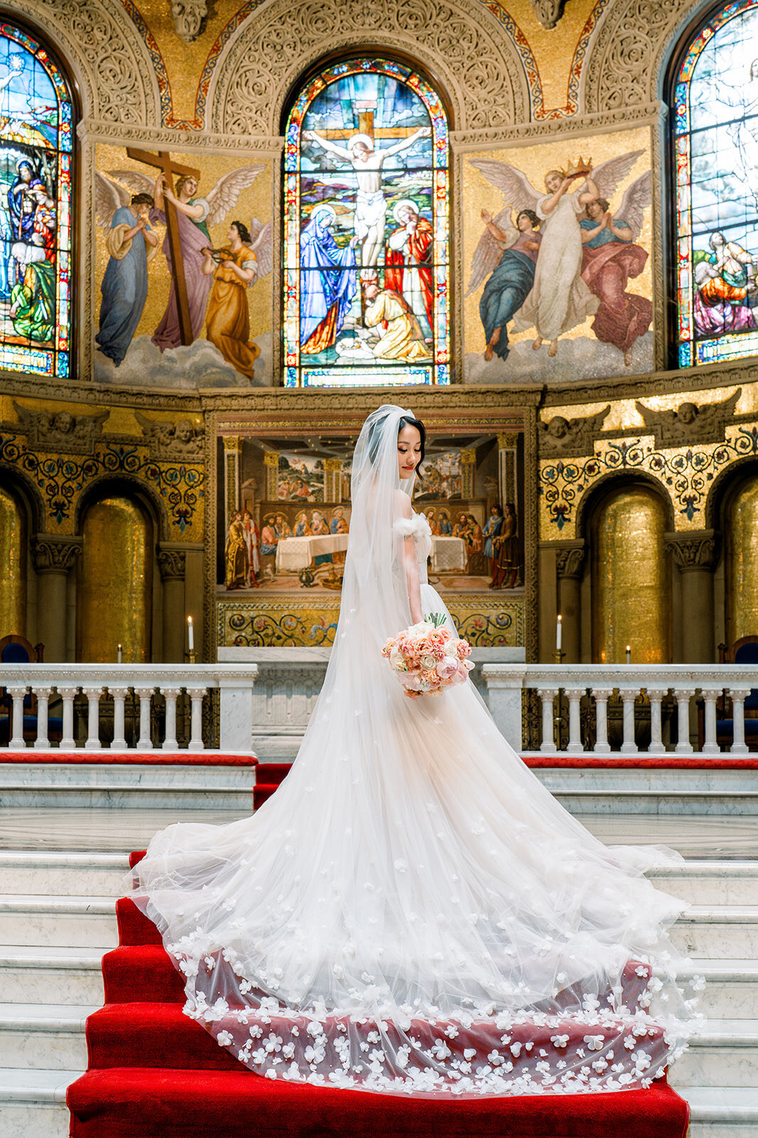 The bride stands elegantly in front of the altar at the Stanford Memorial Church, showcasing the grandeur of her wedding day in California.