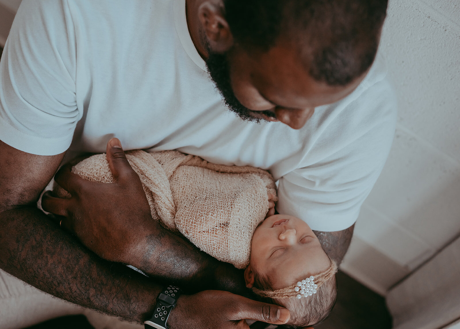 father cradles newborn baby girl in his arms during photoshoot in parker colorado