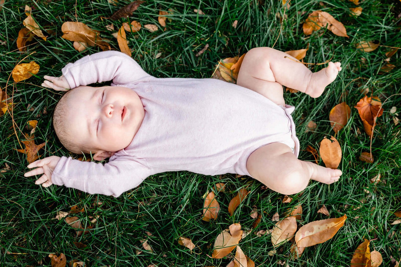 Baby girl laying in grass