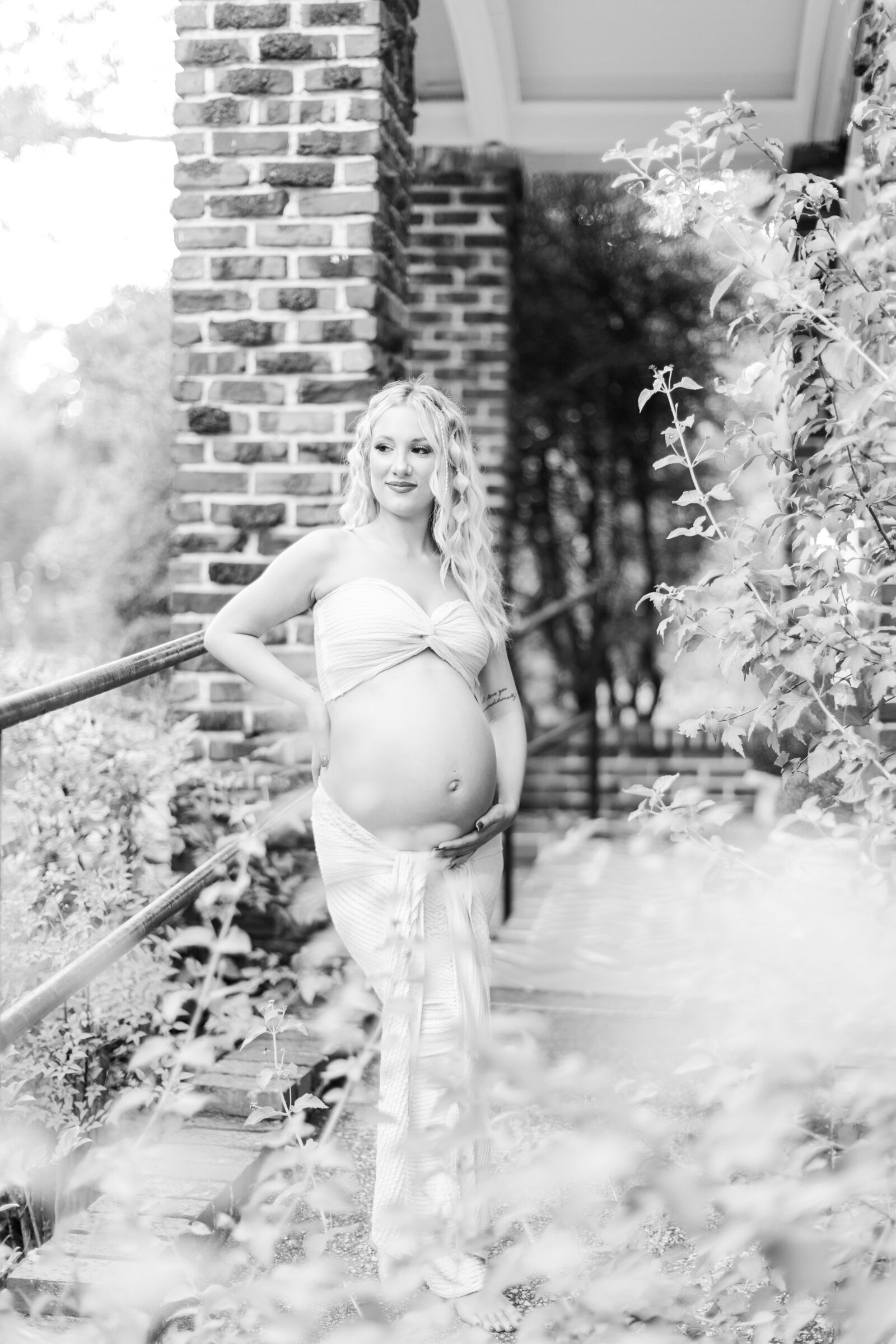 Artistic black and white maternity portrait of Cassidy framed by natural elements, photographed by Abby Bell Photography.