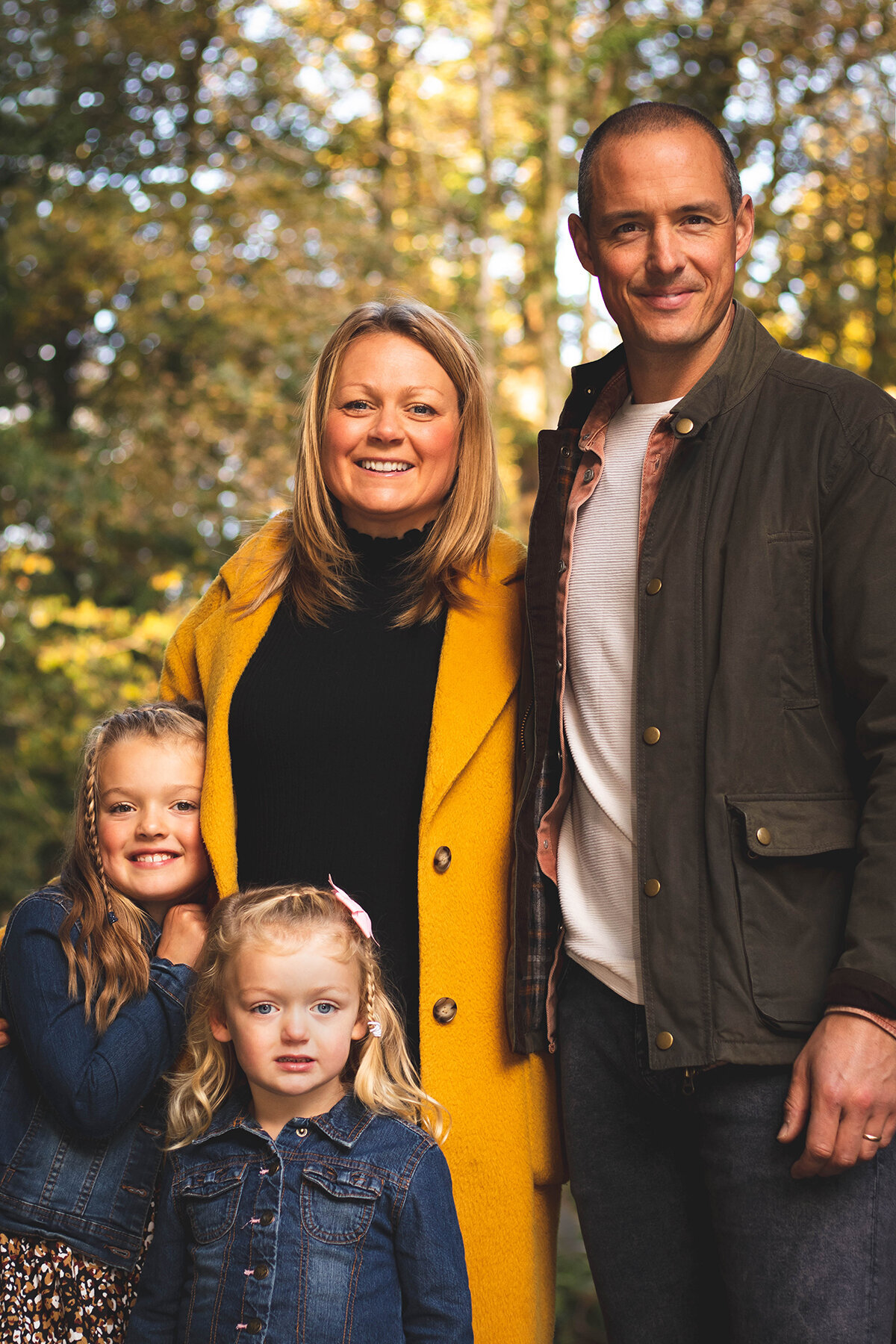 Family smile at the camera during woodland photoshoot