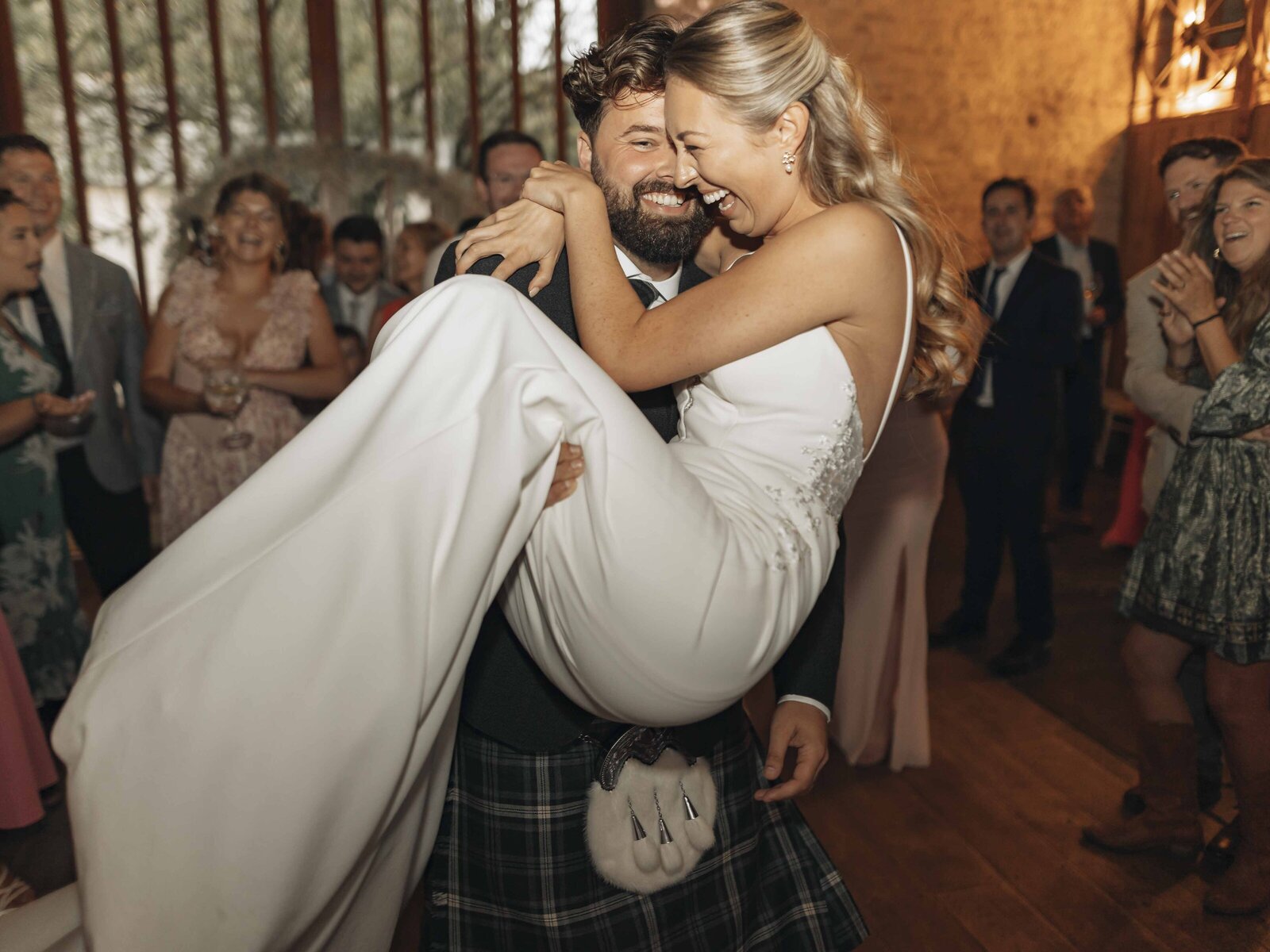 groom carrying bride on the dance floor