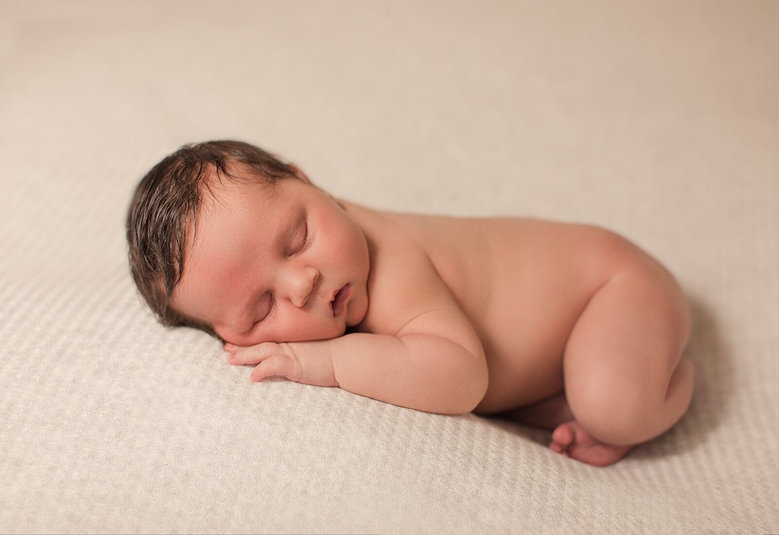 newborn baby sleeping on light gray background