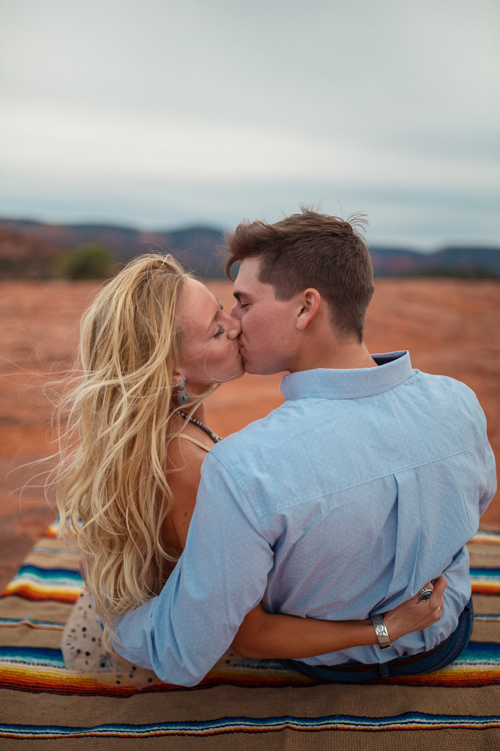 couple kissing with red rock views