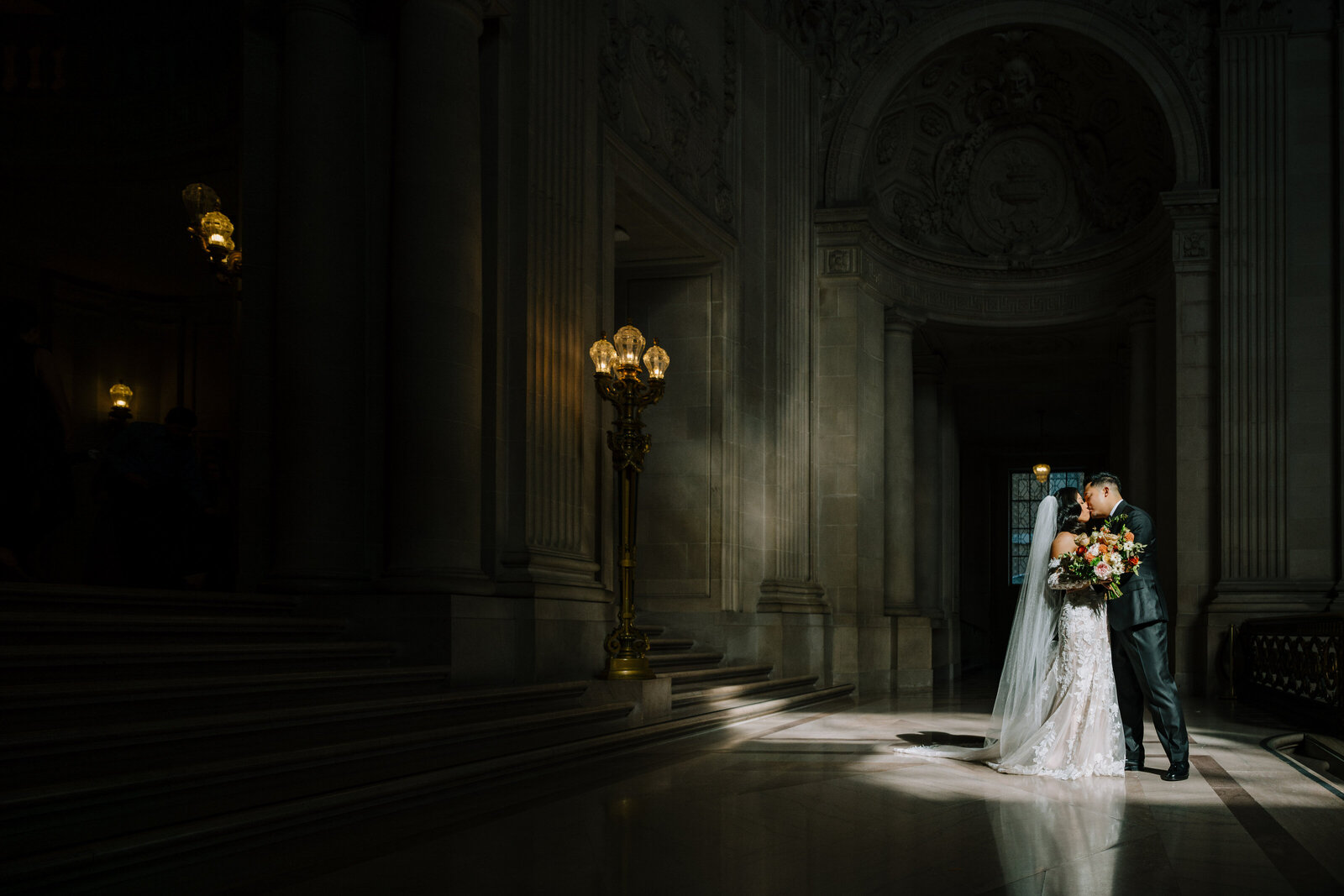 a bride and groom kissing at the historic SF City Hall 