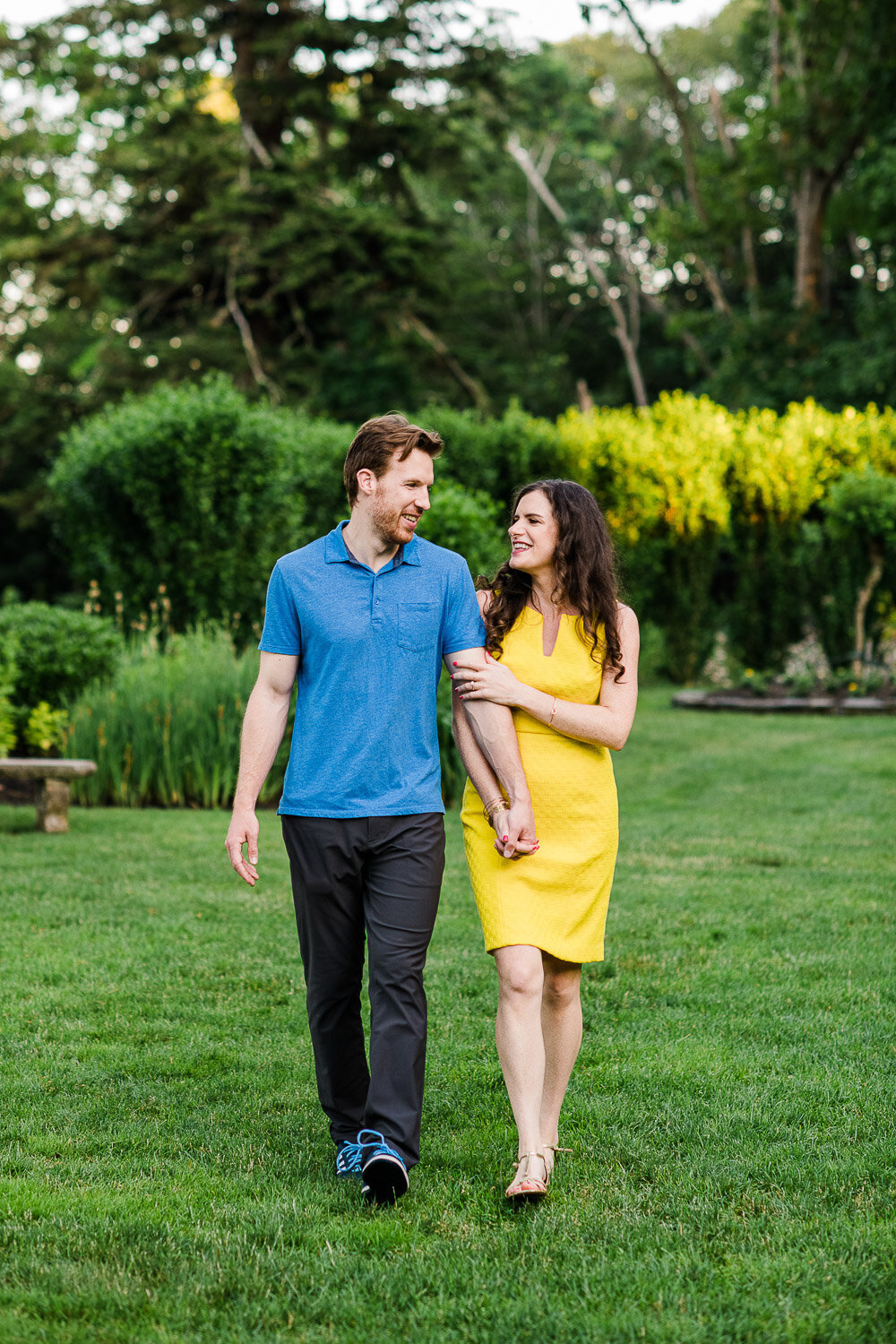 couple holding hands walking in garden