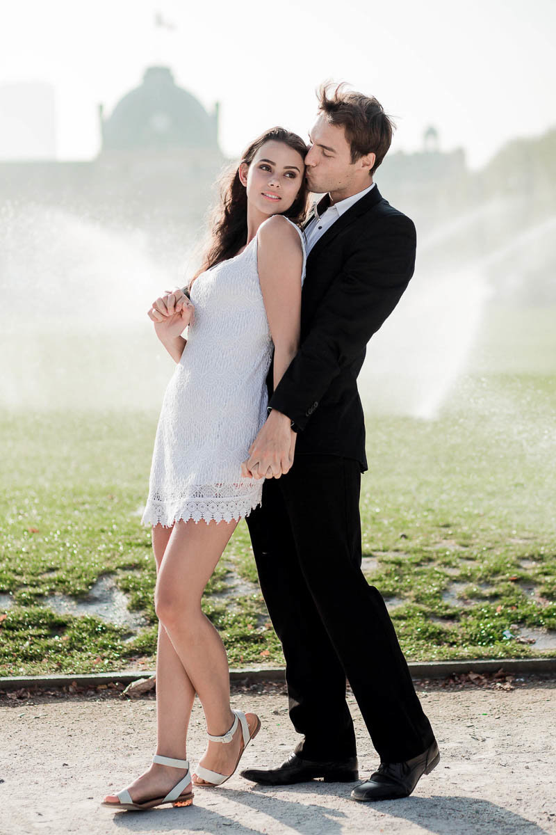 Bride and groom stand in front of the morning sprinklers, Champ de Mars, Paris, France