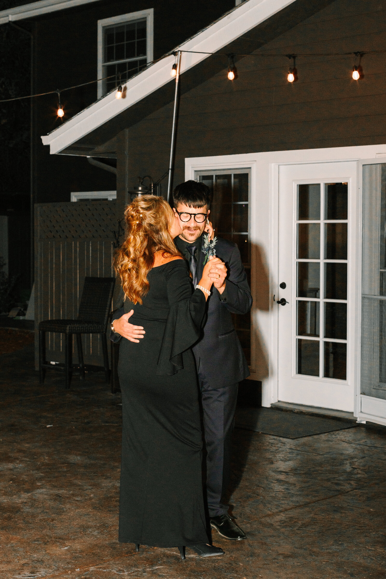 Nighttime first dance between a groom and his mother.