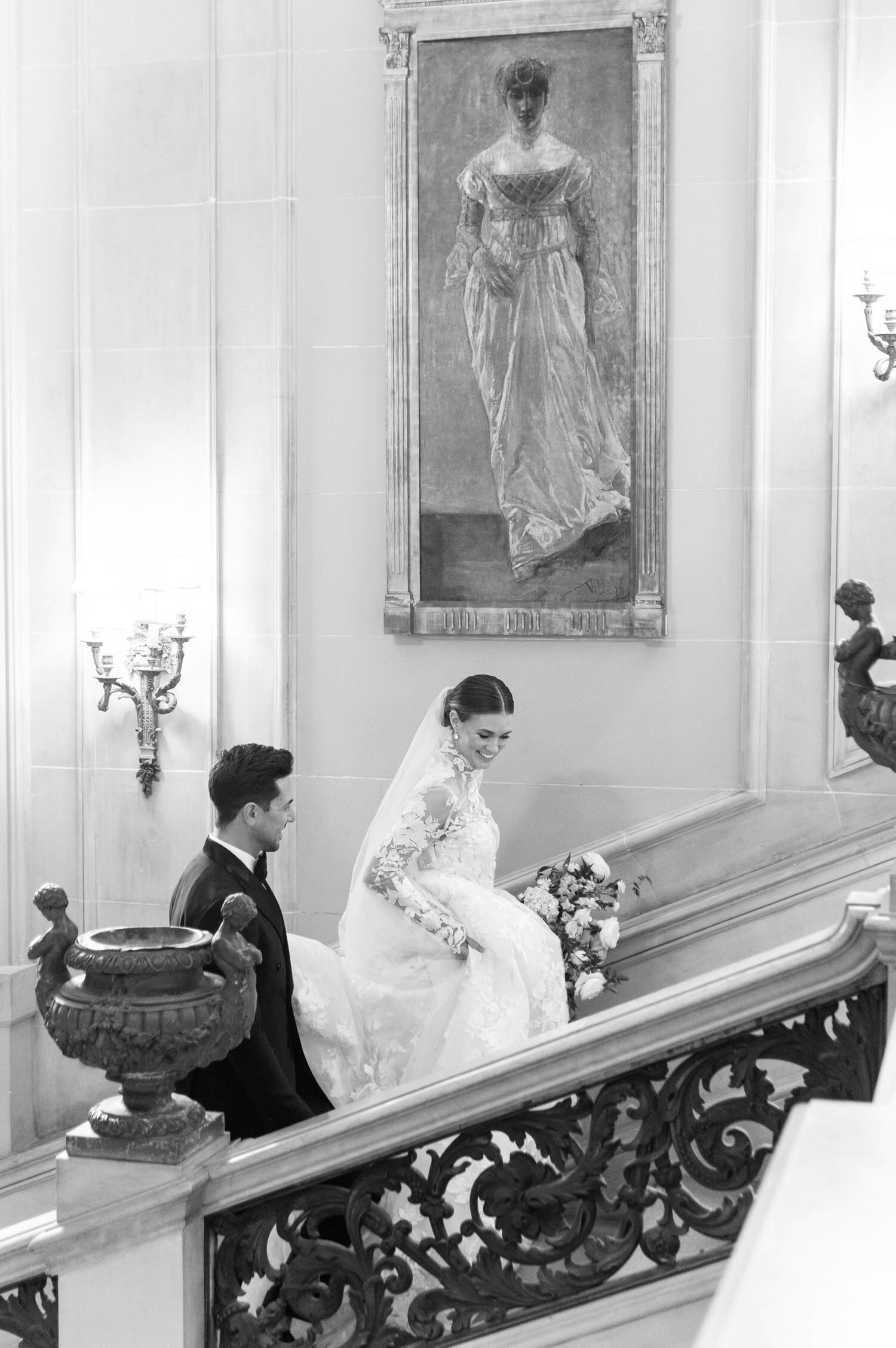bride and groom walking up a marble staircase