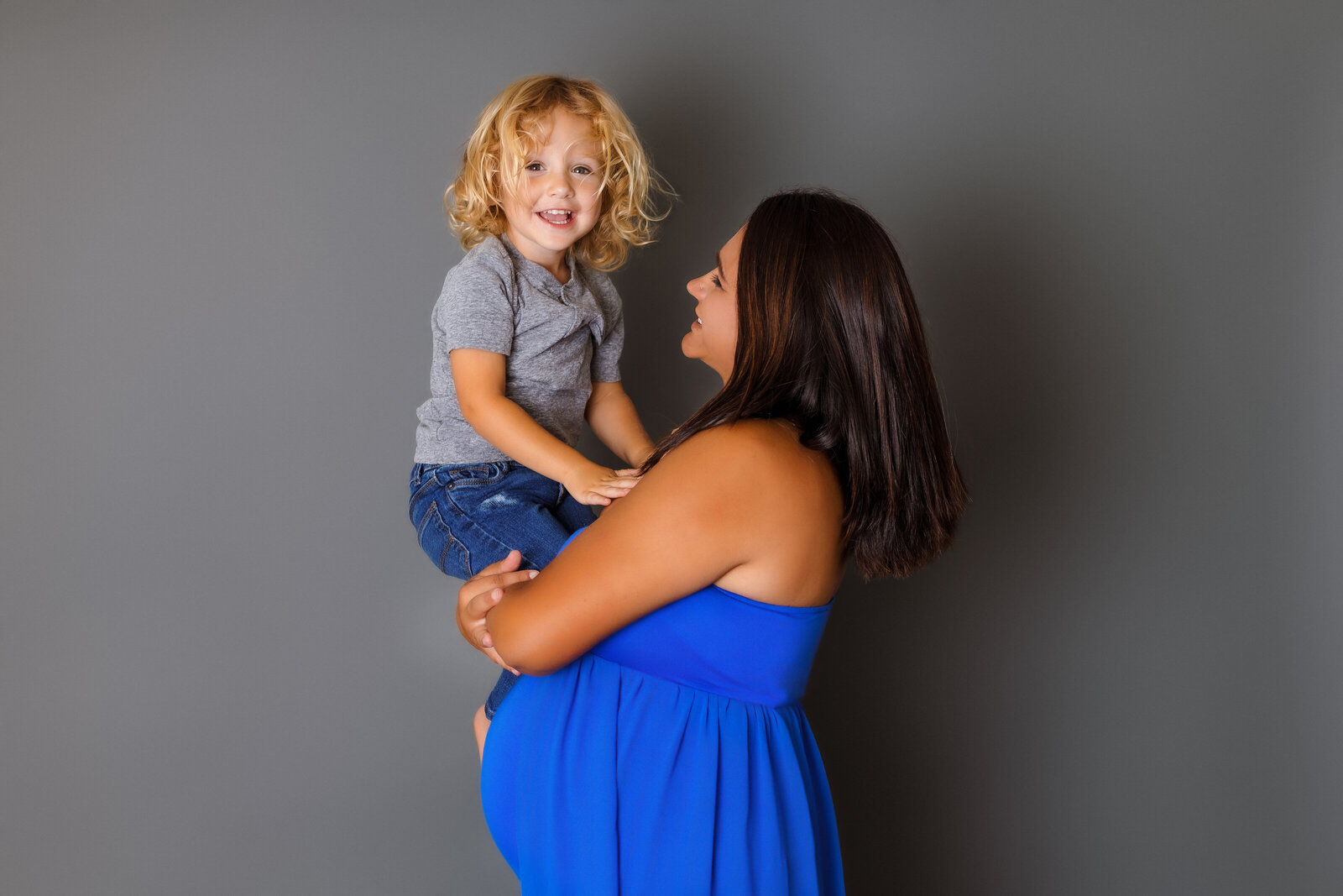Maternity Photographer, a pregnant mother holds her toddler in her arms
