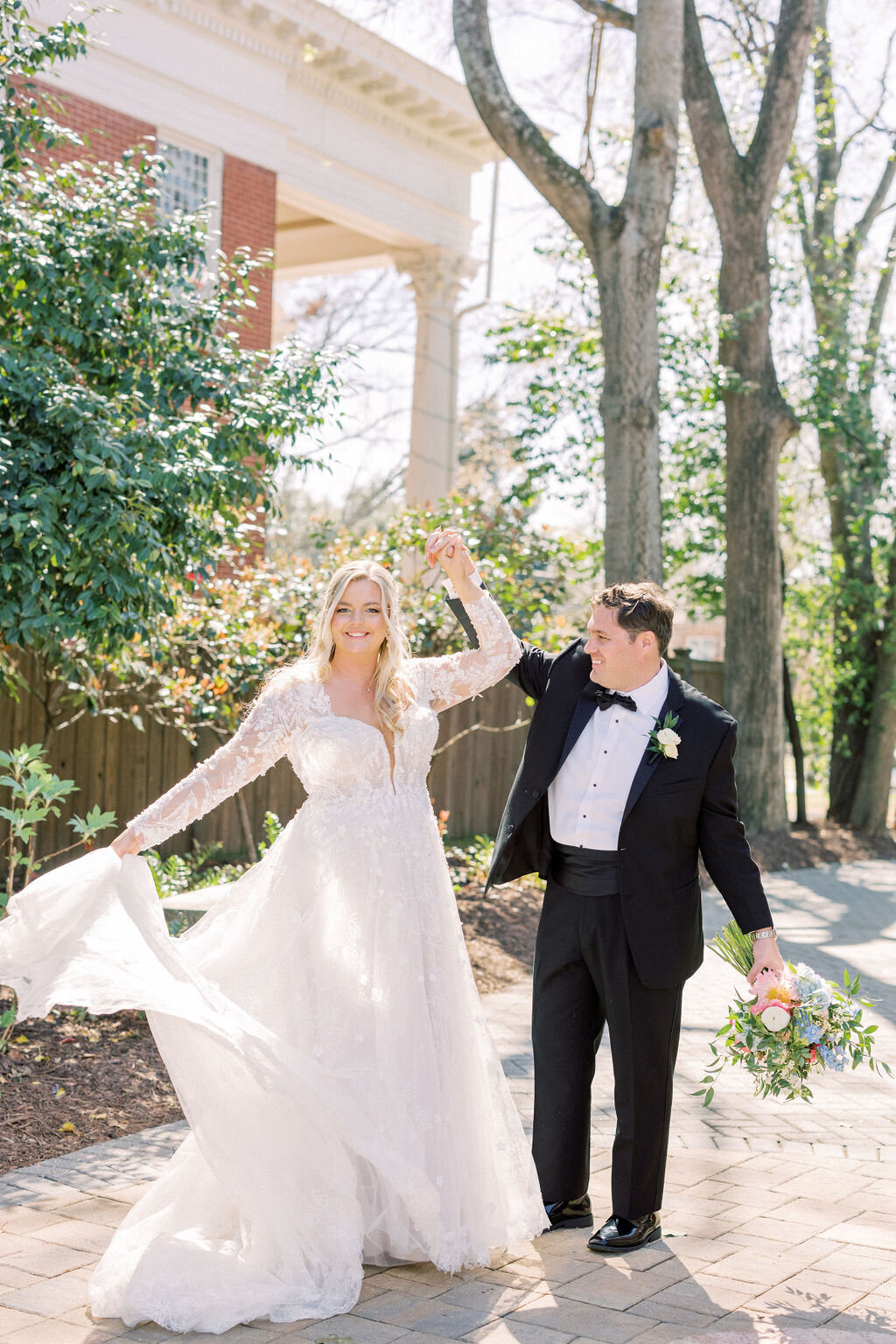 woman twirling her dress while holding groom's hand