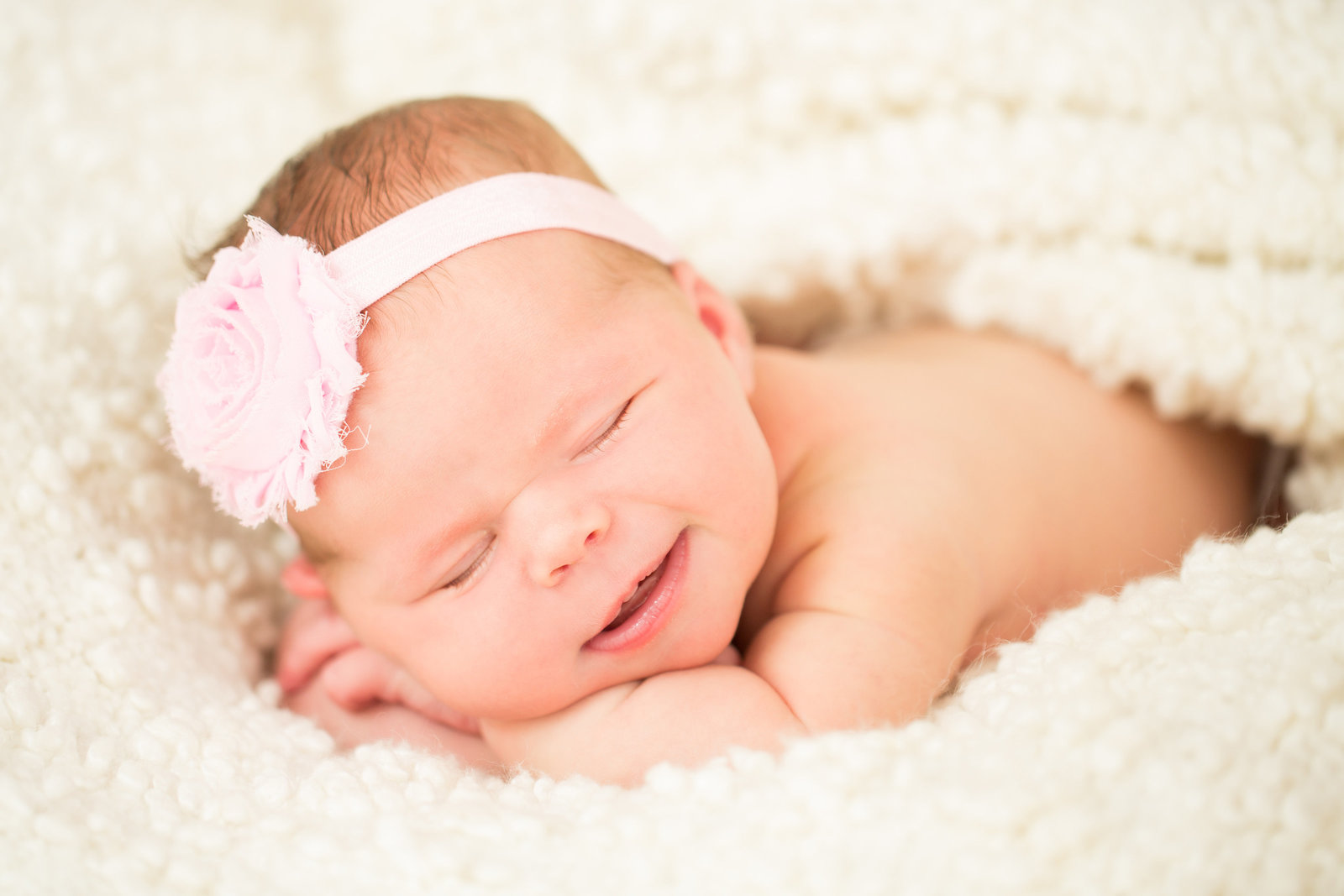 san diego newborn photography | newborn with pink headband and flowers newborn smiling
