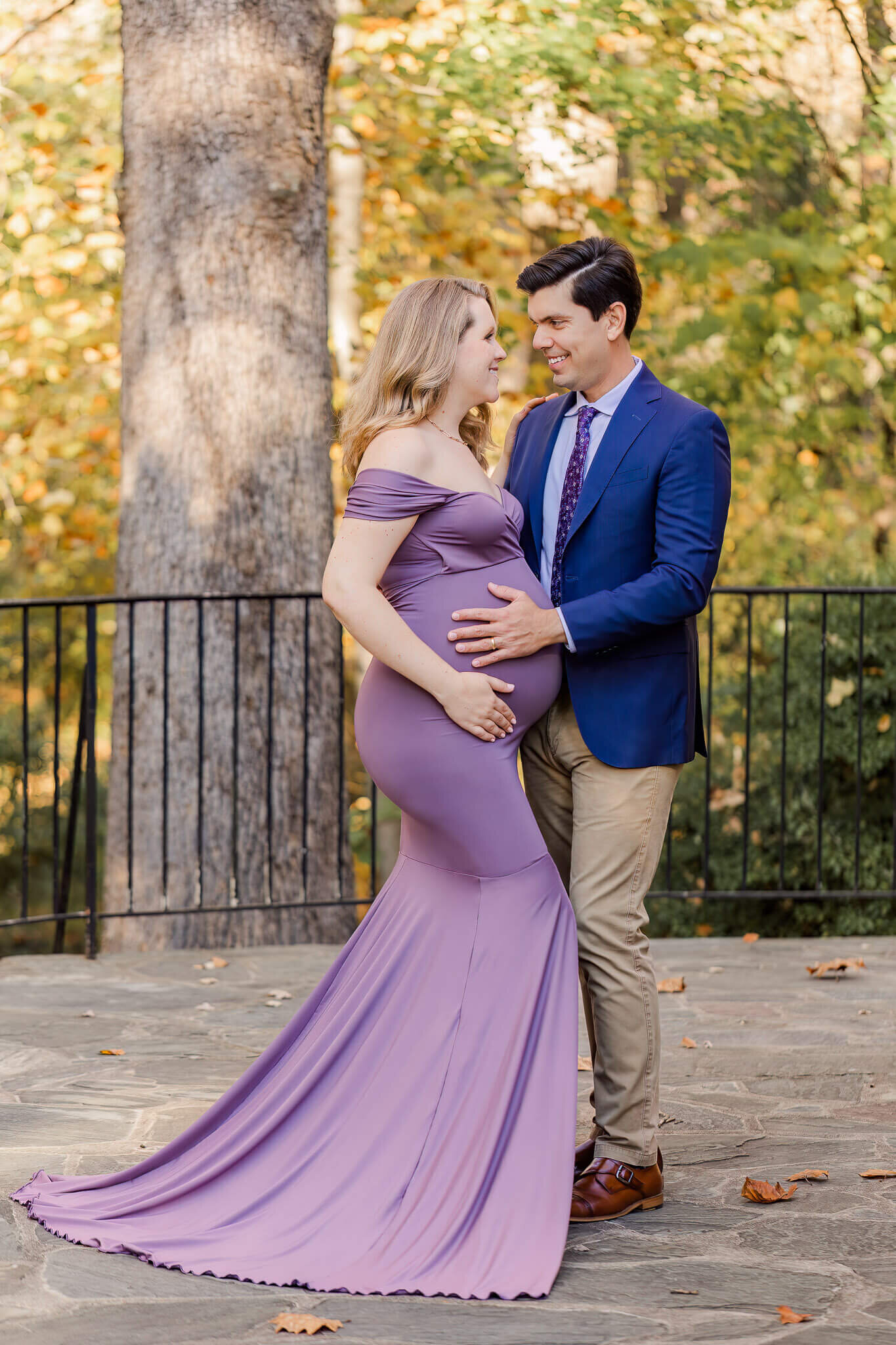 A beautiful couple smiling at each other during their maternity photos in Centreville.