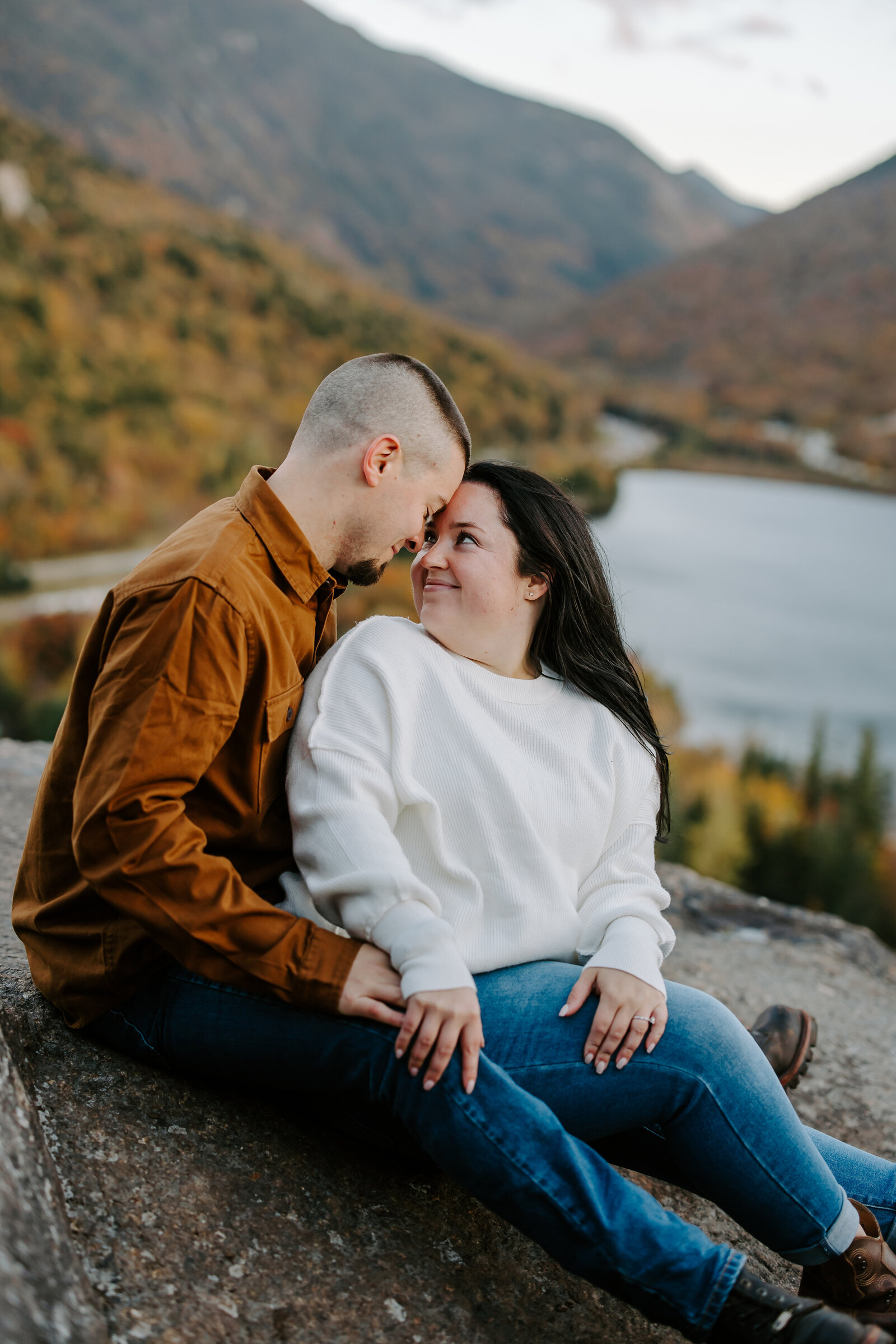 Bride and groom touch foreheads during engagement session at Artist's Bluff in Lincoln, New Hampshire