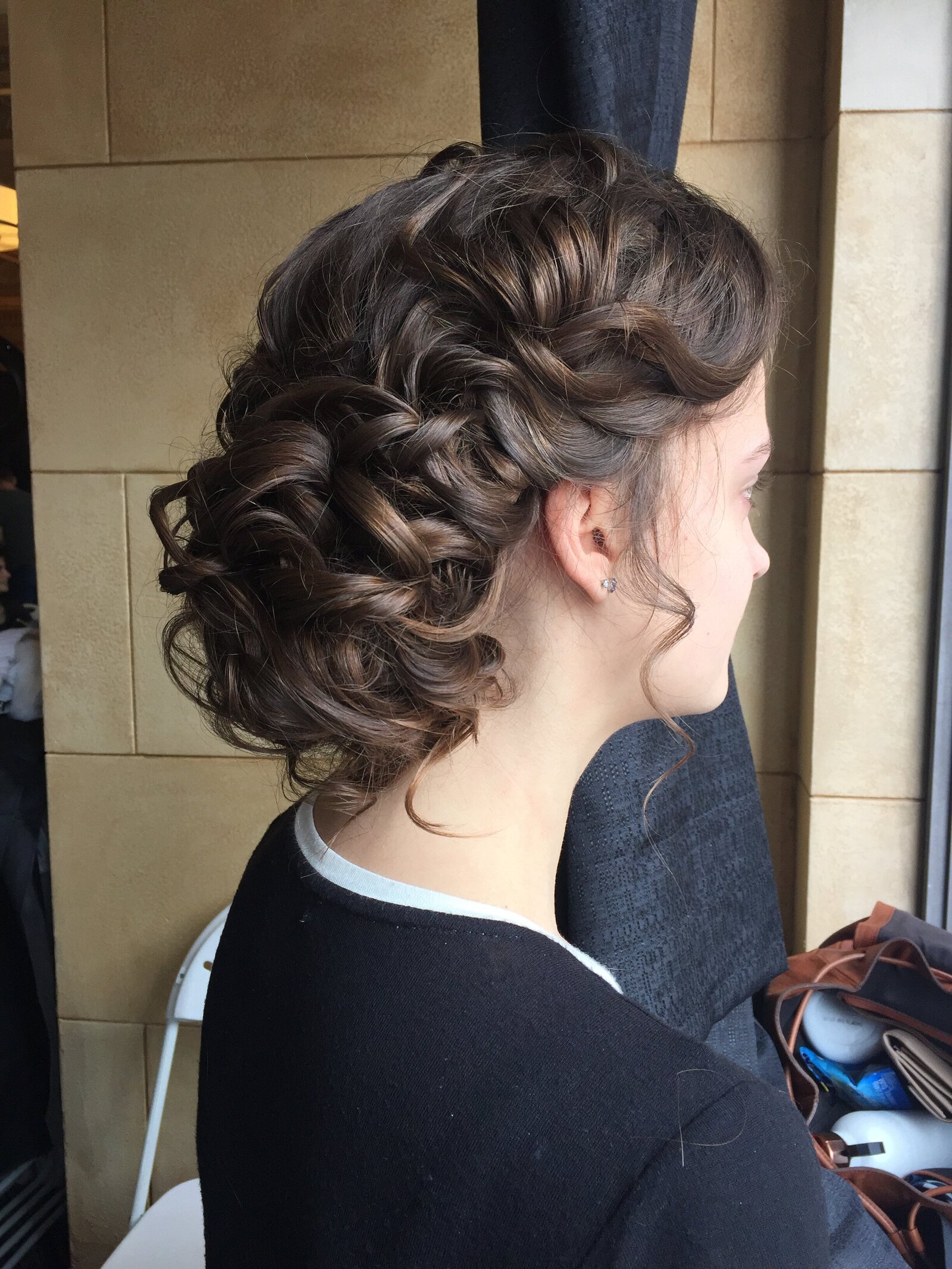 Curly side bun with side detail.  Bridal hair Kansas City stylist