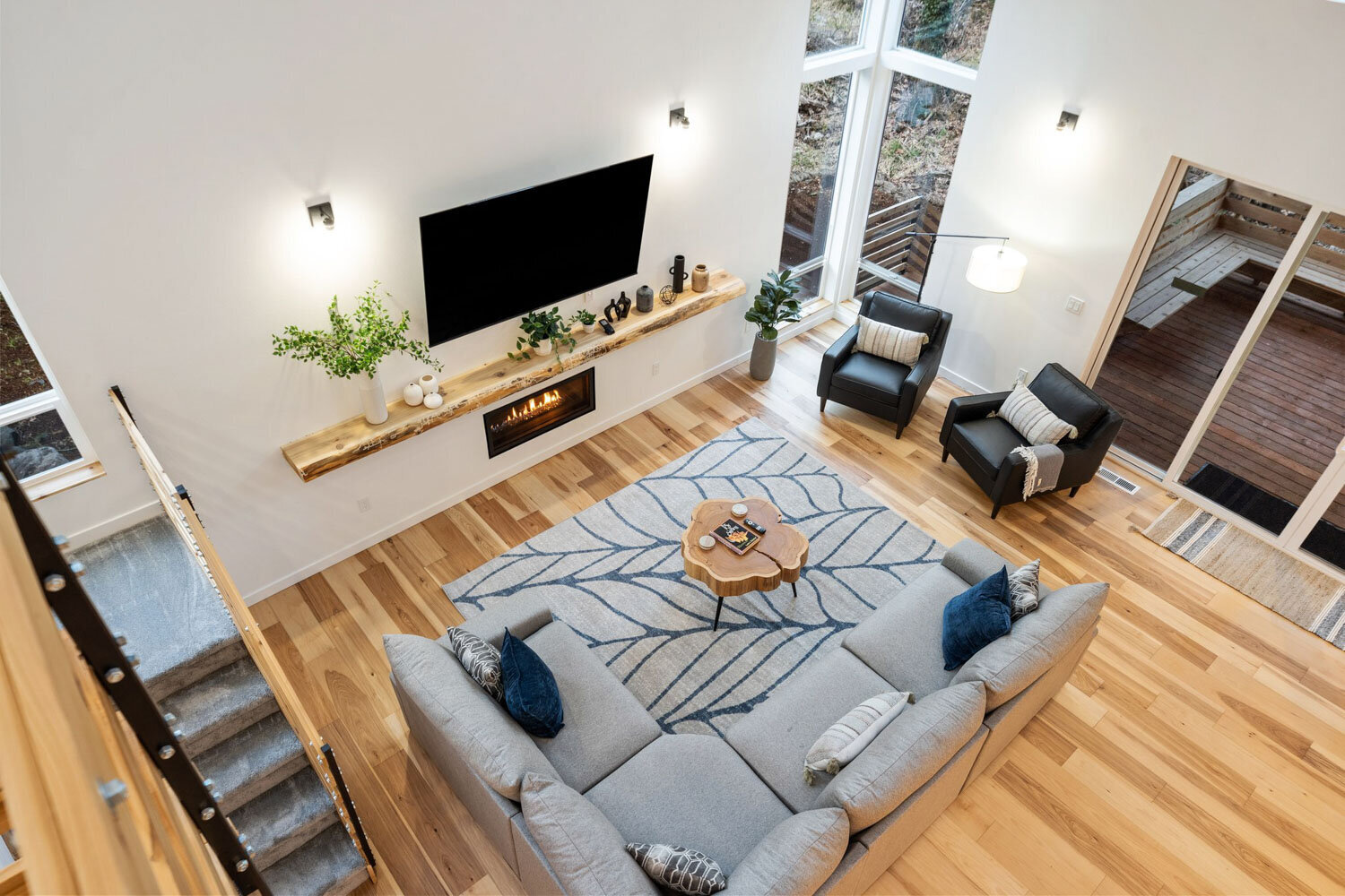 Overhead view of a cozy living room with a large sectional and tall windows