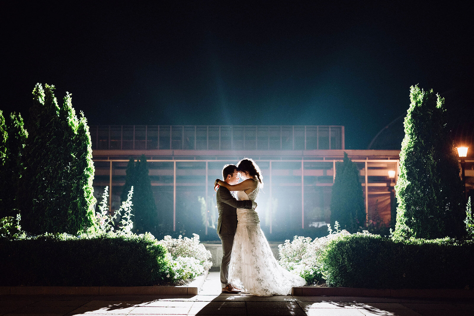 bride and groom hugging at night with backlight