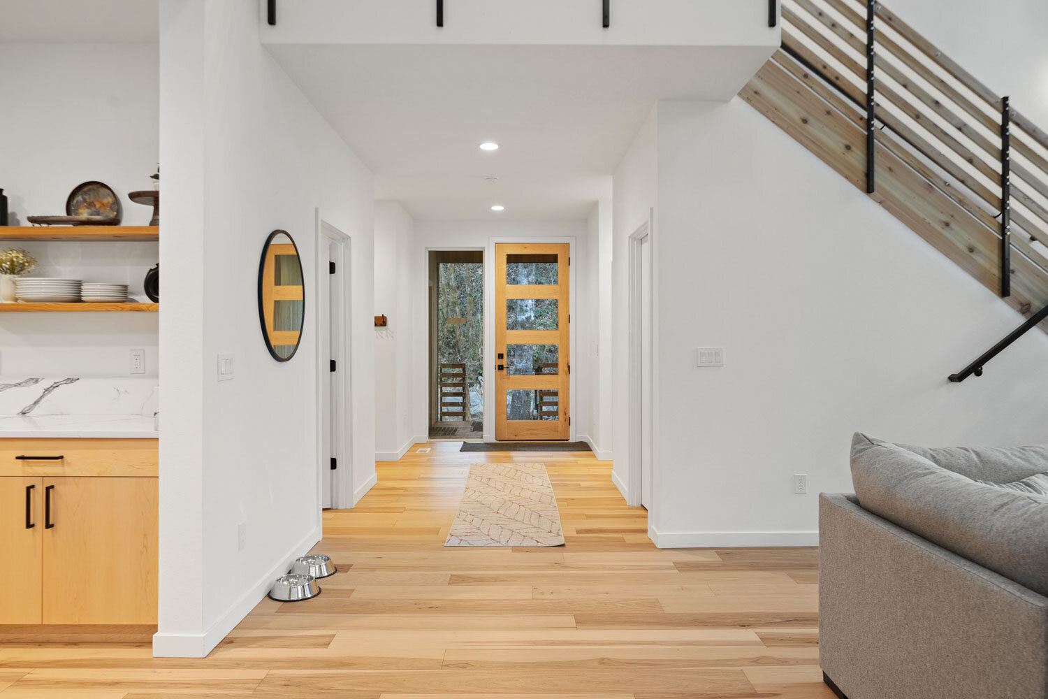 Bright hallway leading to a wooden front door with modern decor