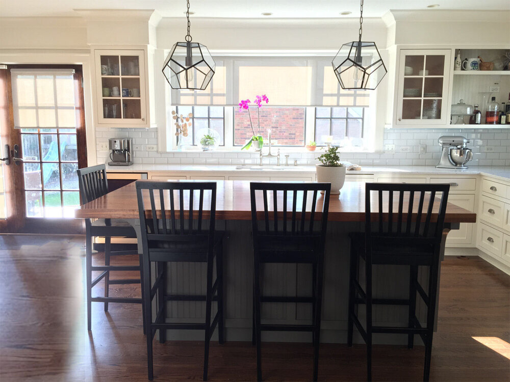 White kitchen with subway tiles and black and brown island