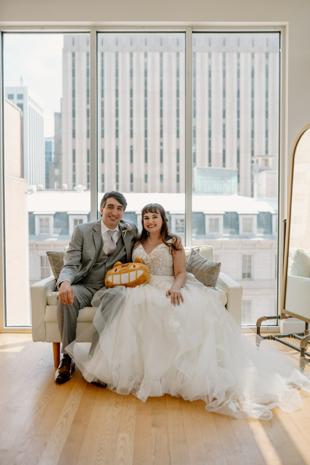Bride and groom sitting down with outdoor building view