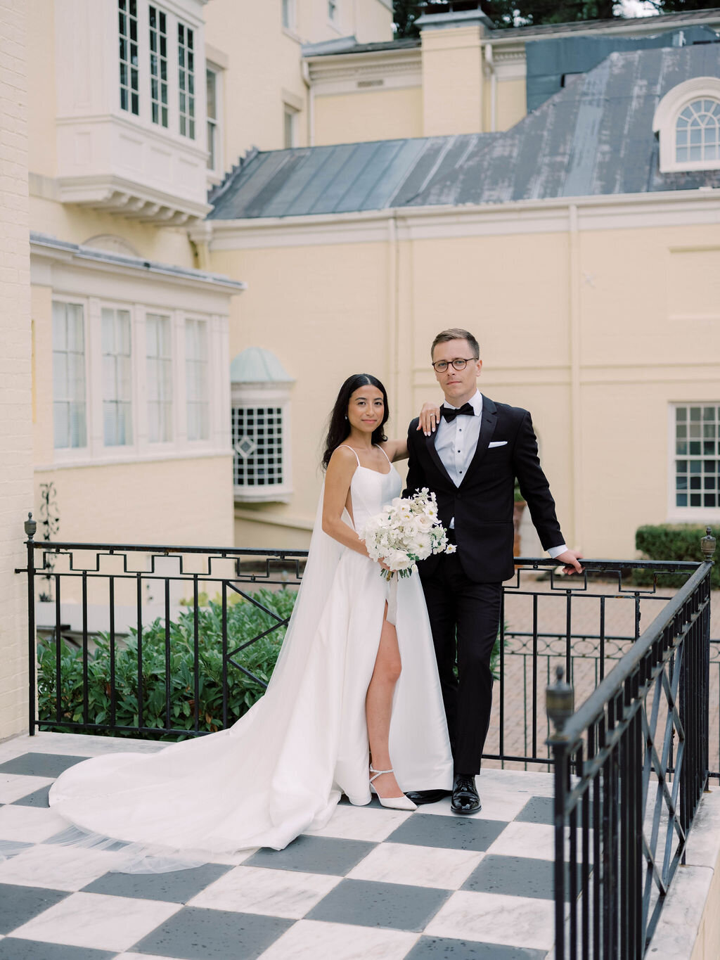 Portrait of the bride and groom at the Evergreen Museum Mansion balcony terrance.