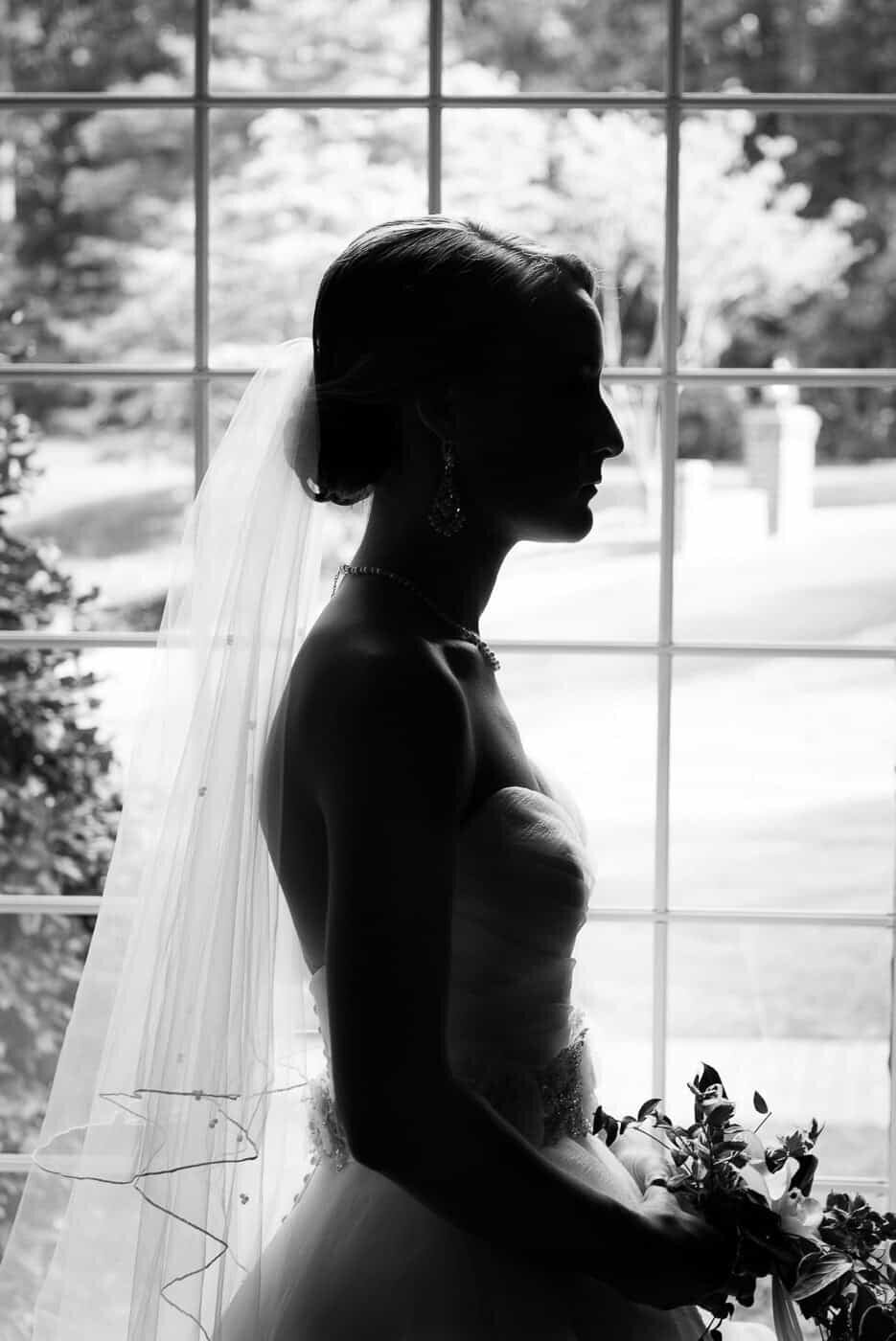 A silhouette of a bride in front of a window before her wedding in Northern Virginia