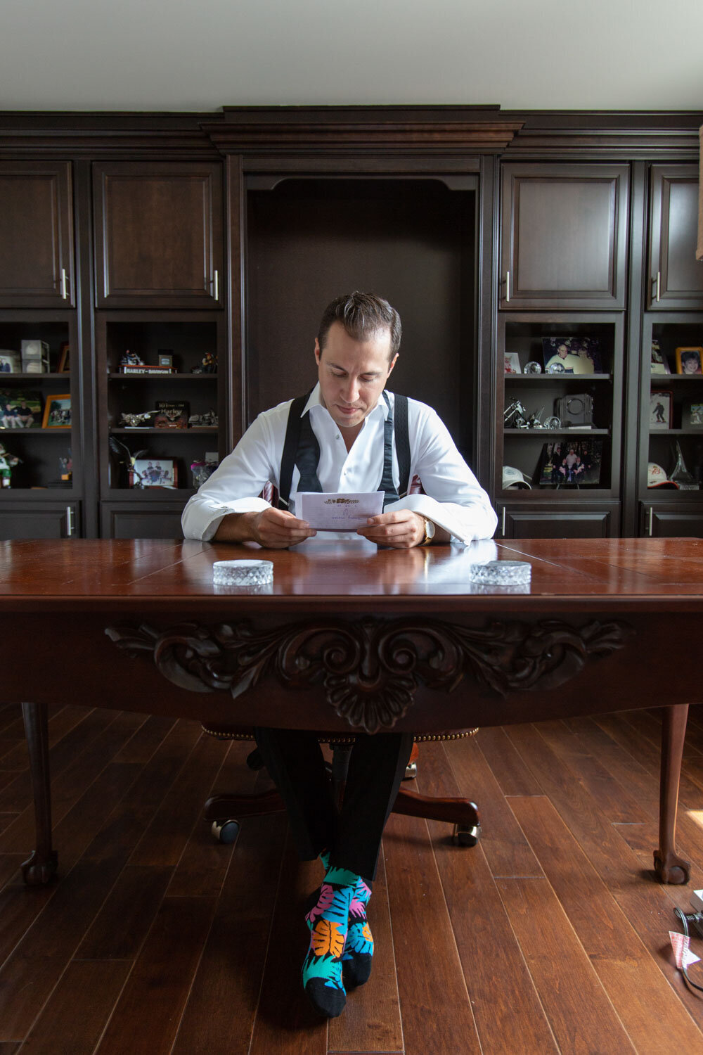 A man is sitting at a desk reading a letter