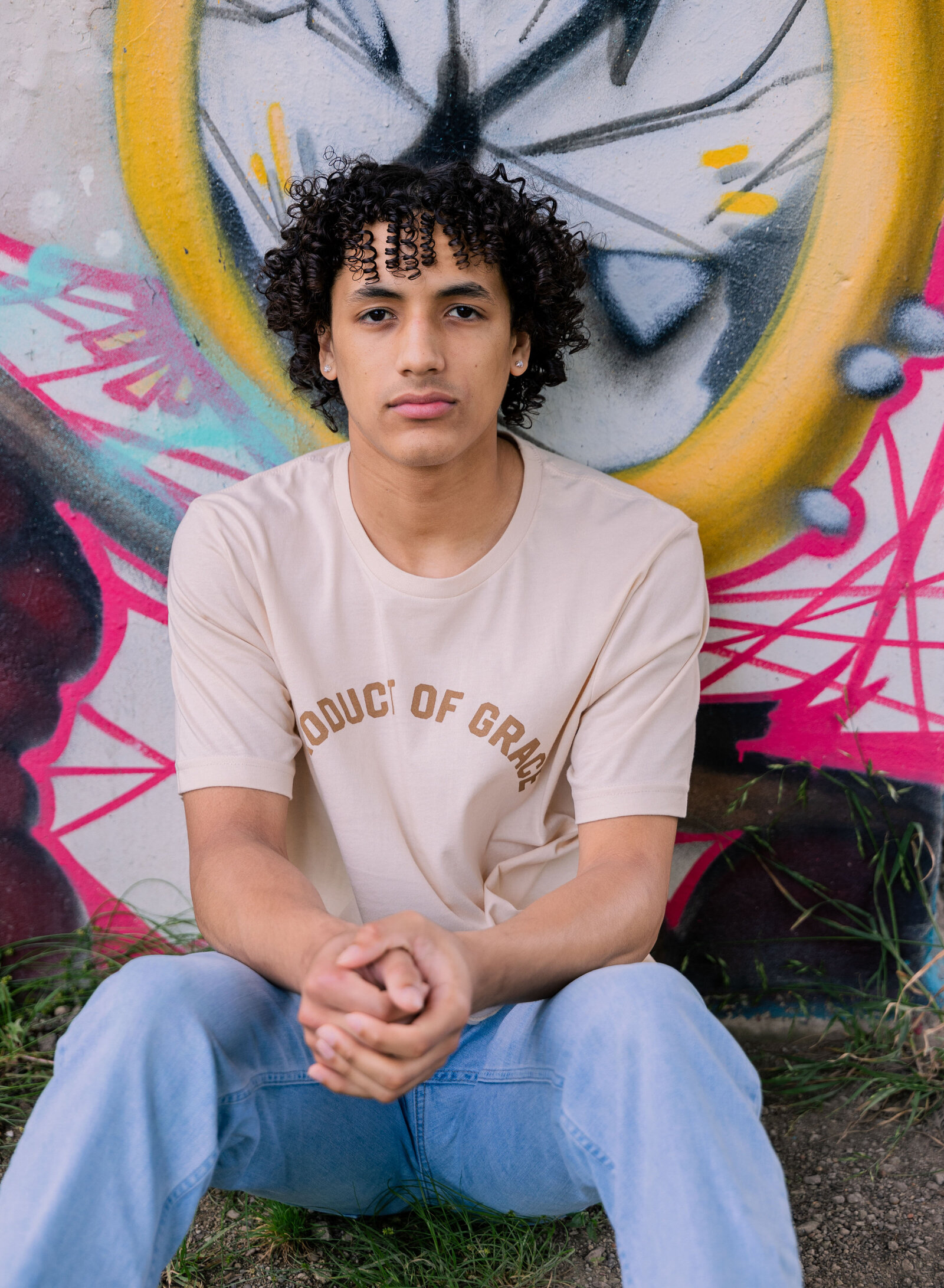 senior boy seated with grafitti