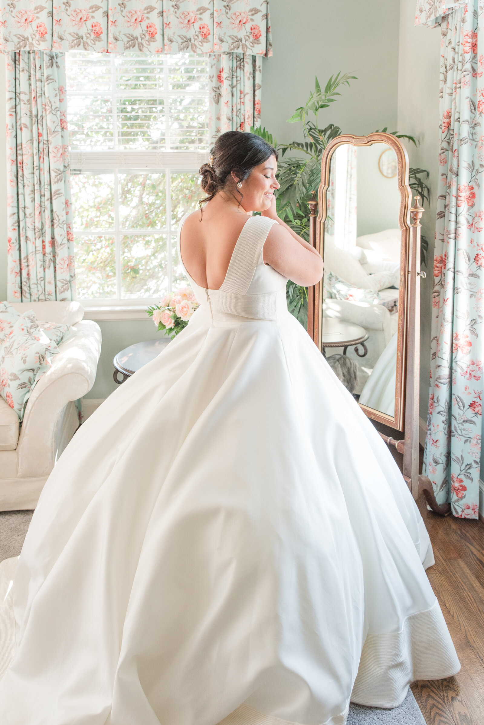 bride putting on earrings on wedding day at brittland estates
