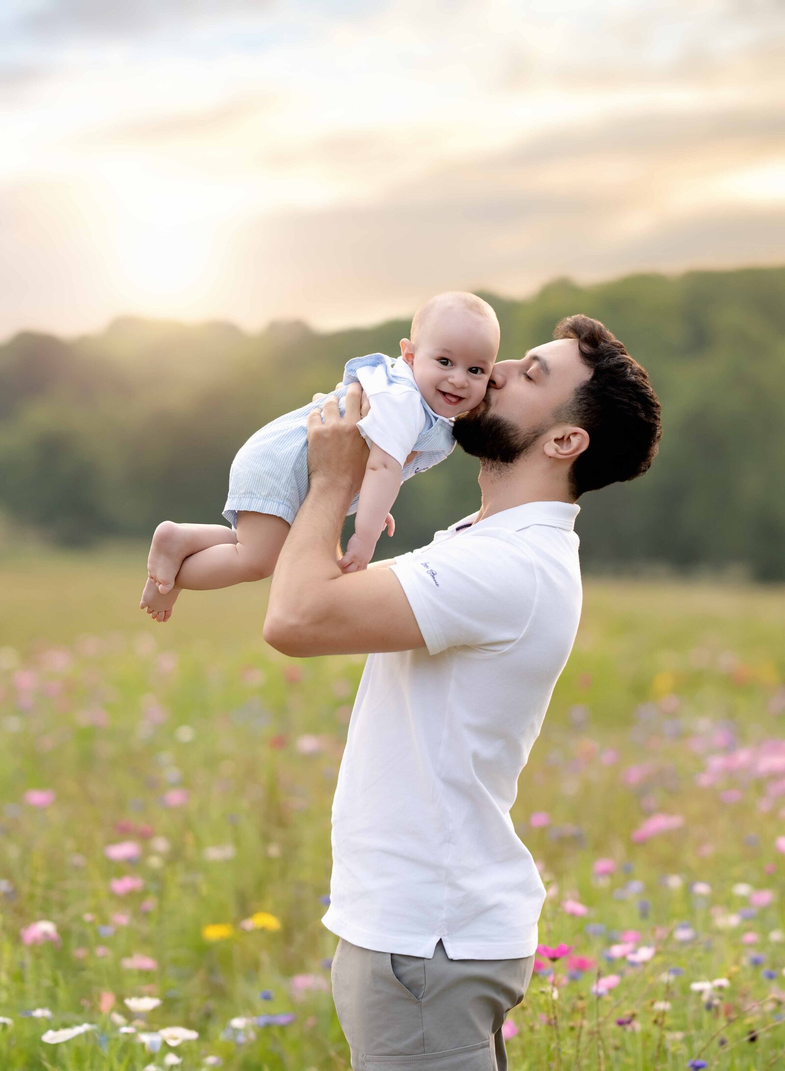 Dad holding baby in air and kissing his cheek. Photo taken at Prospect farms near Atlanta, GA